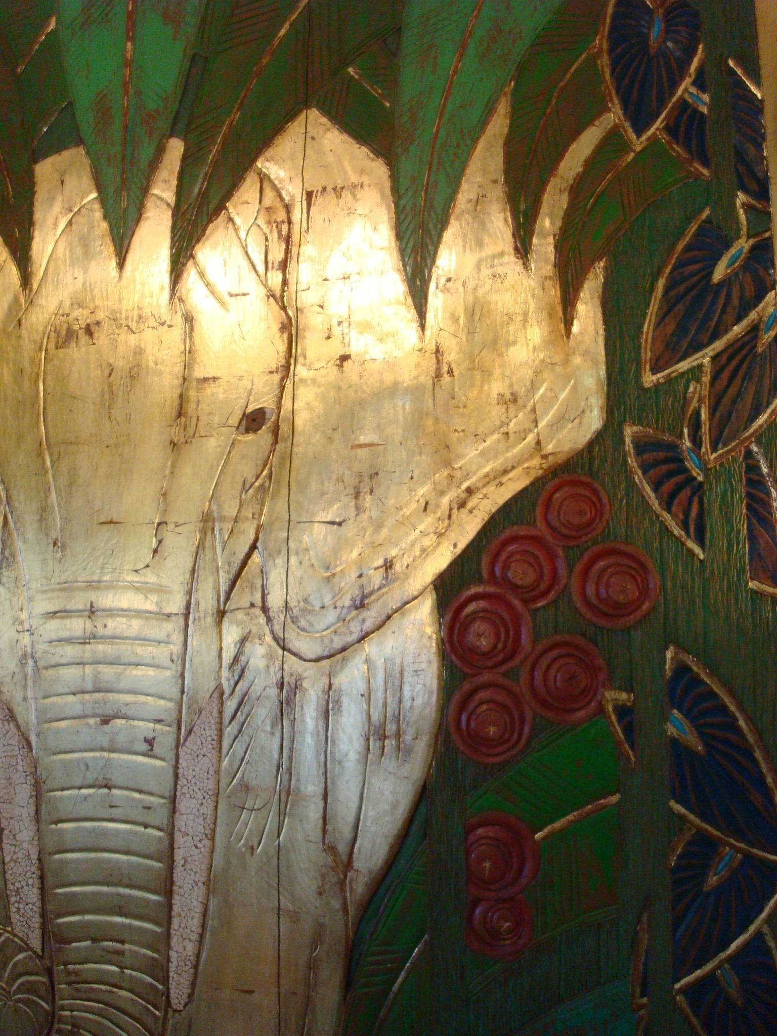 Fantastic Art Deco wall panel. Polychromed wooden carved sculpture.
The Panel shows the frontal view of an elephant charging toward the viewer with ears extended. The beast, walking forward through a dense jungle, bring to mind powerful Assyrian