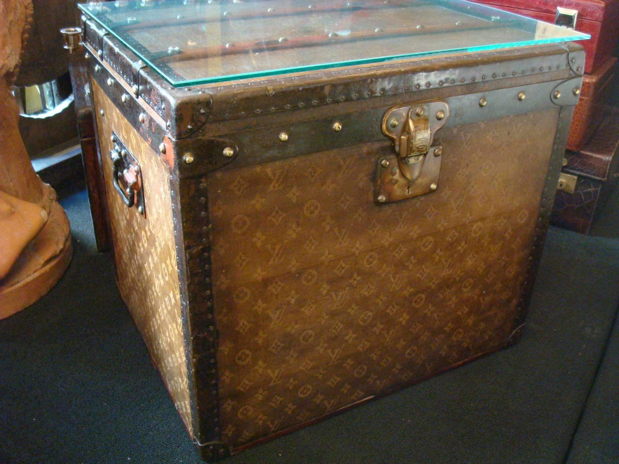 1890s woven canvas Louis Vuitton Tisse monogram steamer hat trunk side table. It has the perfect size to be a sofa side table. It's prepared for that, as it has a glass.
Louis Vuitton woven canvas monogram hat trunk.
Brass lock. Steel handle and