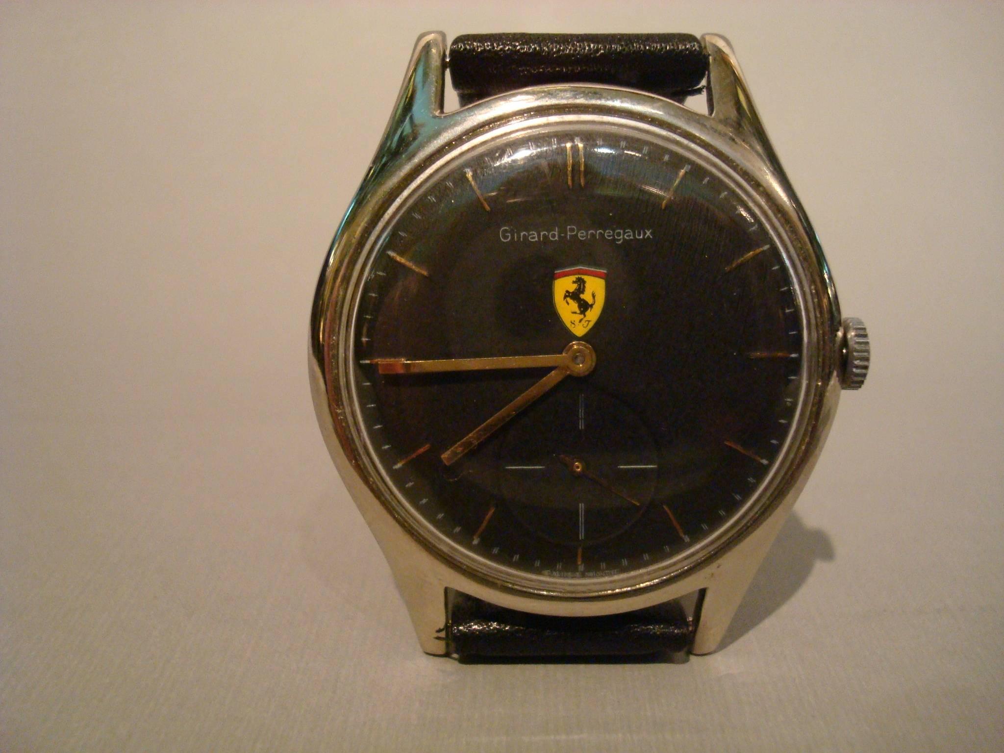Rare 1960s Girard Perregaux Ferrari watch, featuring a black face, with yellow logo, silver case and presented on an aftermarket leather band. This is a lovely original Girard Perregaux watch and is stamped on the reverse side of the case with both