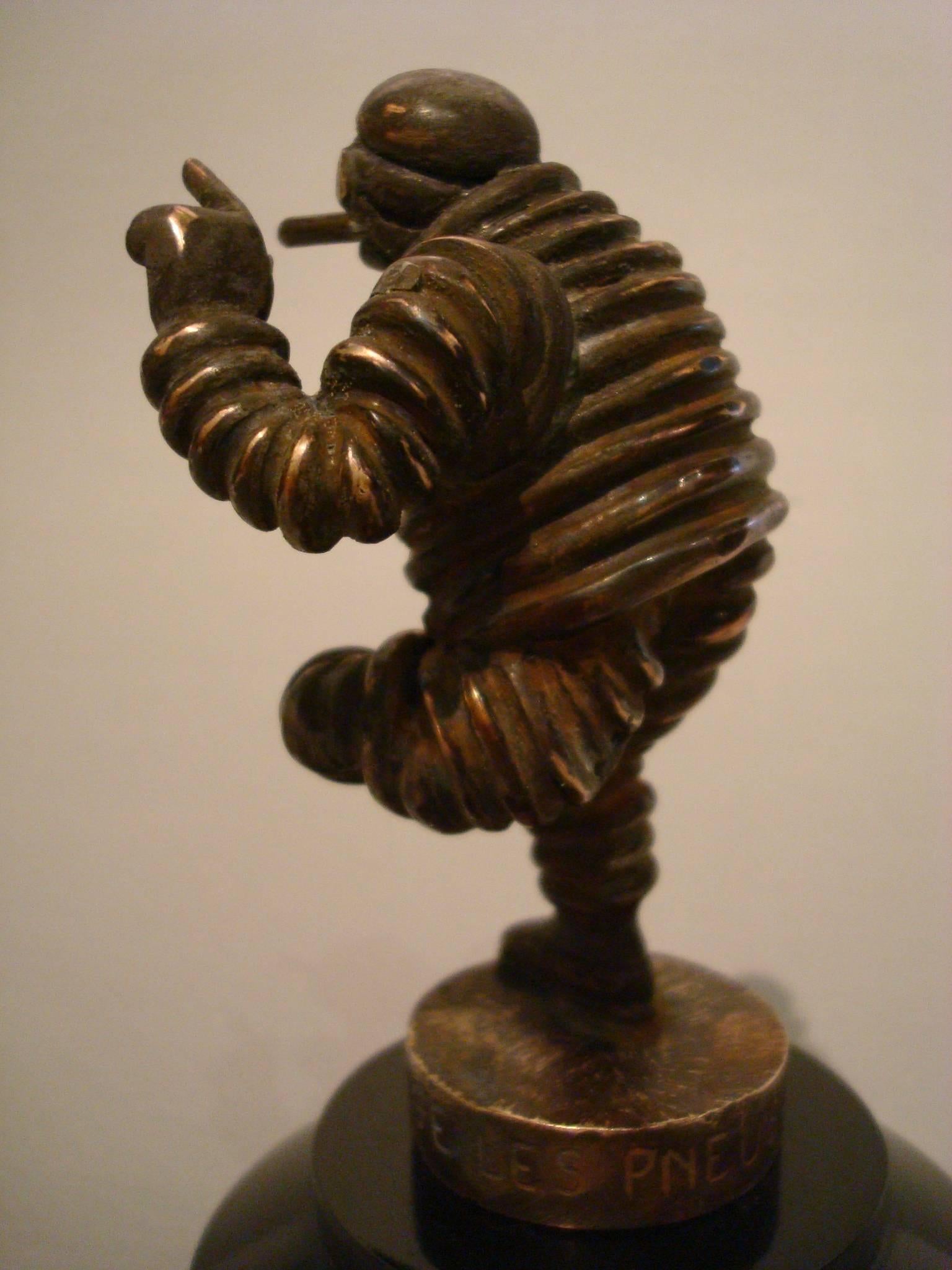 Michelin man bronze car mascot, hood ornament, Automobilia
This is a highly collectible Michelin man bronze car mascot. It´s approximate 4 inch tall depiction of the Michelin man, also known as Bibendum, joyfully raises his arm while jauntily