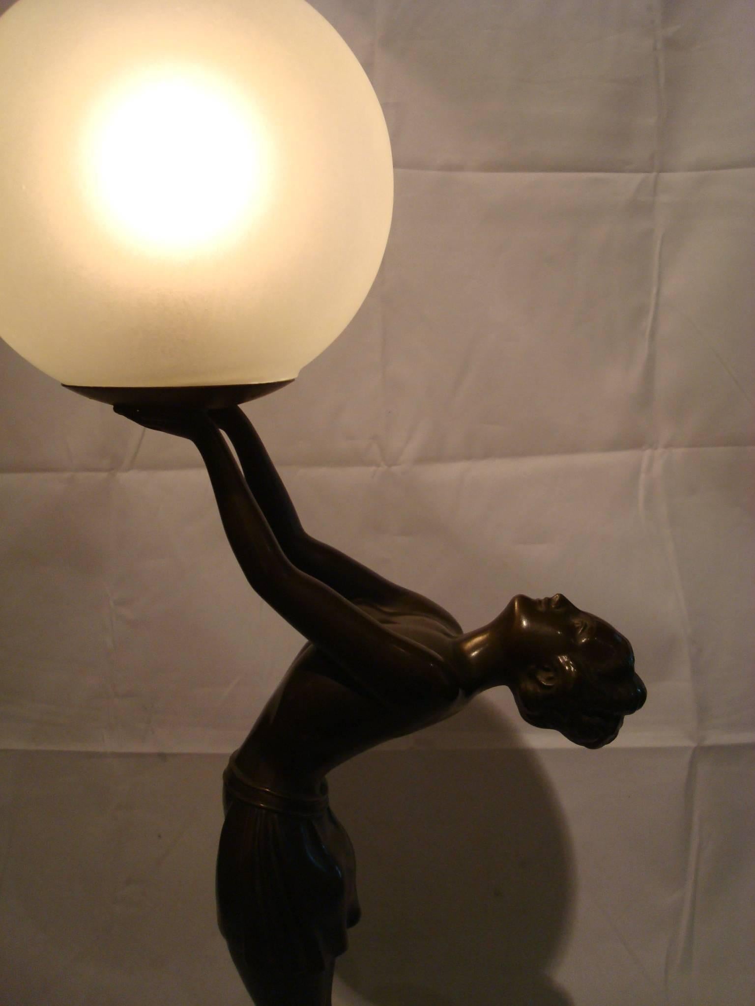 Here is a wonderfully unique statue/ lamp combination. It is done in cold painted cast metal -patinated and all original. The lamp was designed by Balleste. The round onyx base allows for perfect symmetry between this lovely Art Deco lady and she