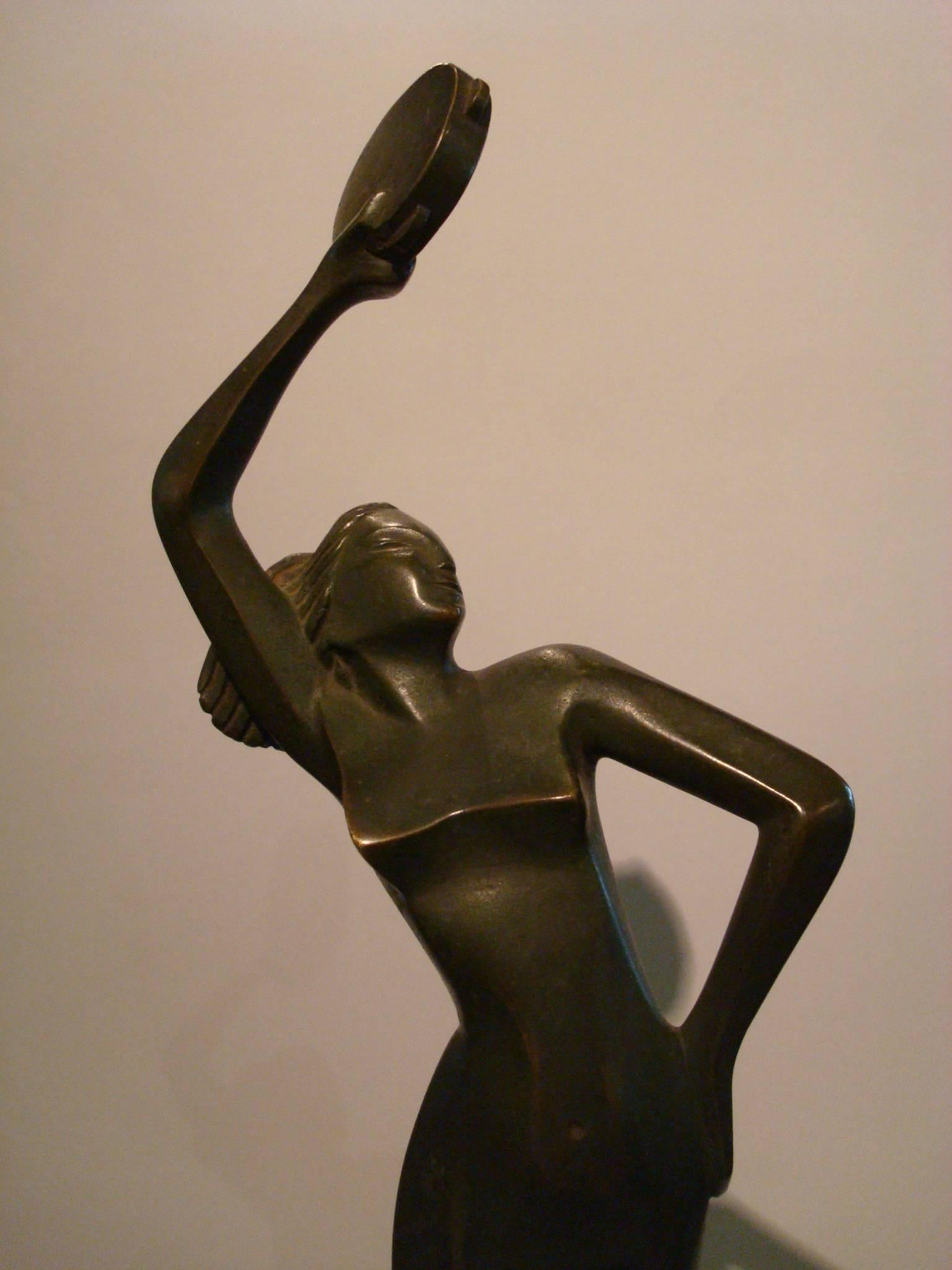 Art Deco Italian figure of a woman dancig with a music  instrument. 
Sculpture of a dancing nude girl. Bronze with a dark green patina.
Mounted over a marble base.