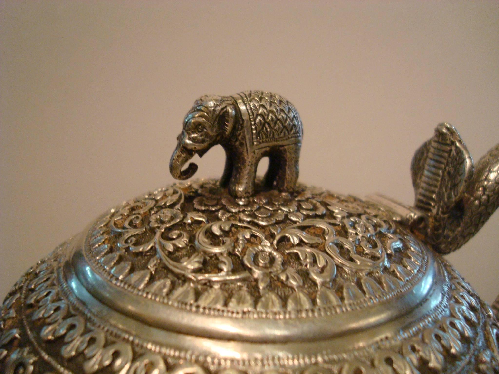 This teapot is a particularly fine example of colonial Indian silversmithing. It´s perfectly formed and finely chased with the Islamic-influenced scrolling tendril and flower pattern against a finely tooled background that is typical of Kutch