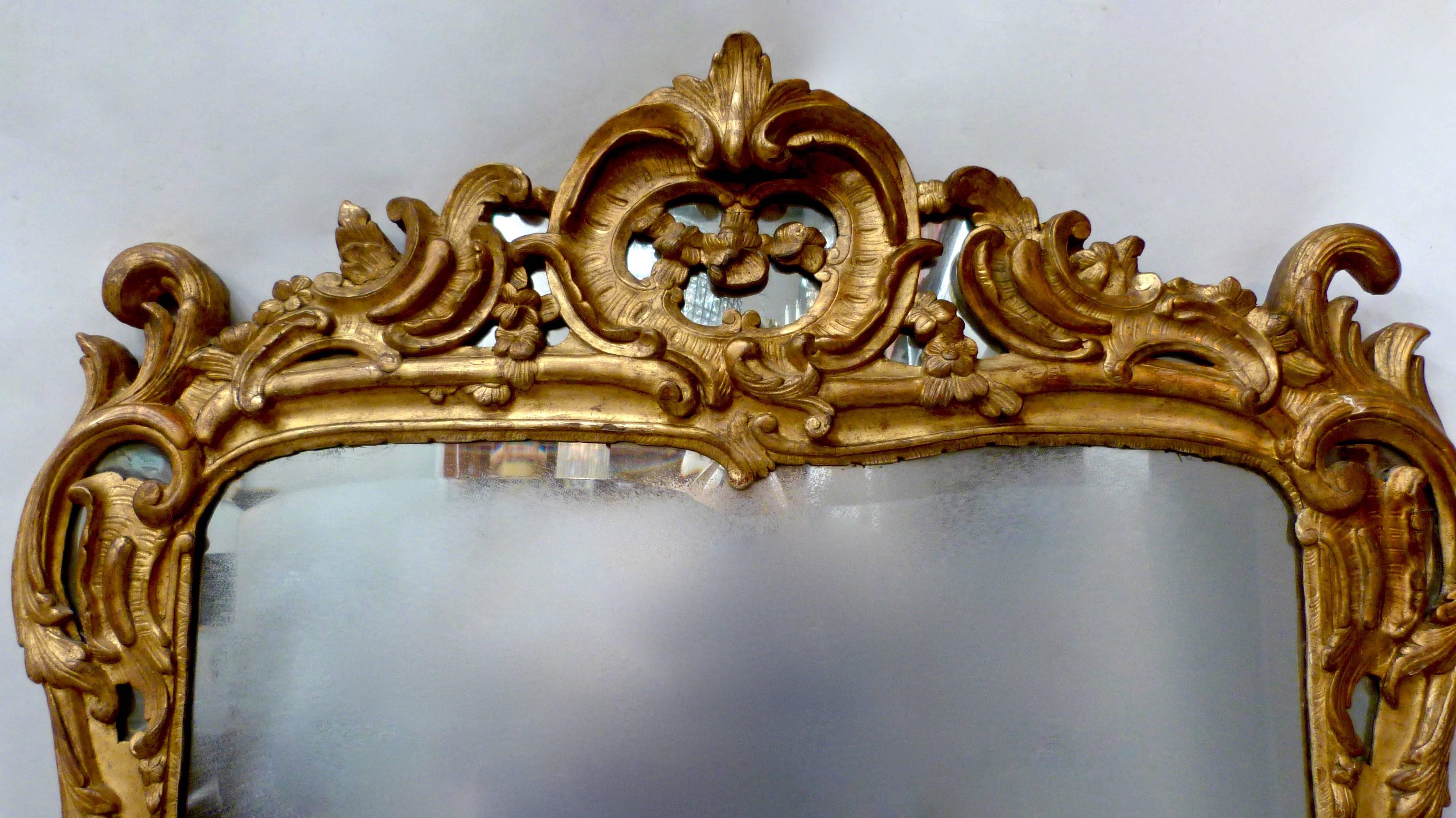 An 18th century Louis XVI carved giltwood mirror with original bevelled glass plate.