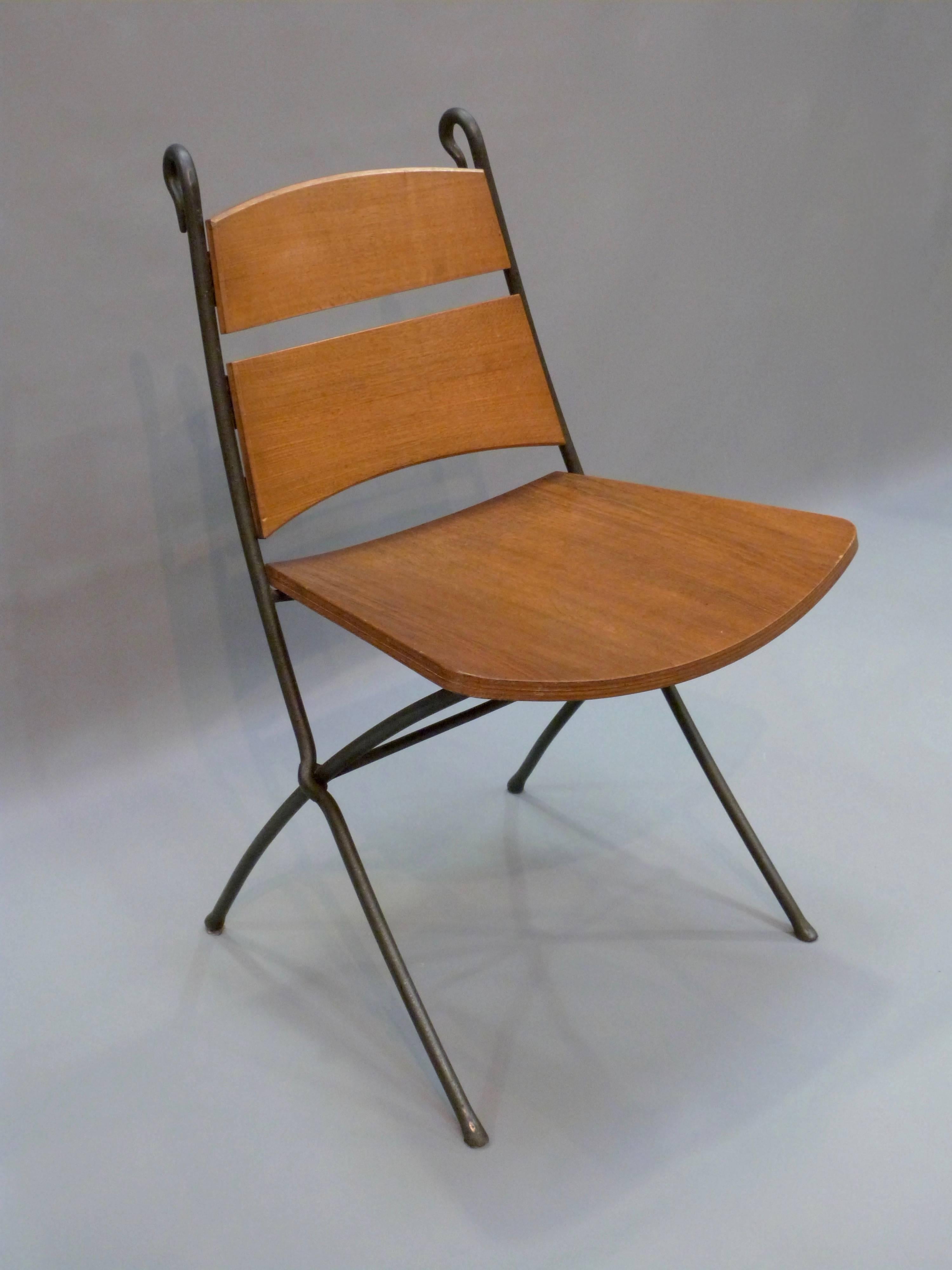 A late 20th century oak and ironwork circular dining table with six matching chairs by Andrew Varah.