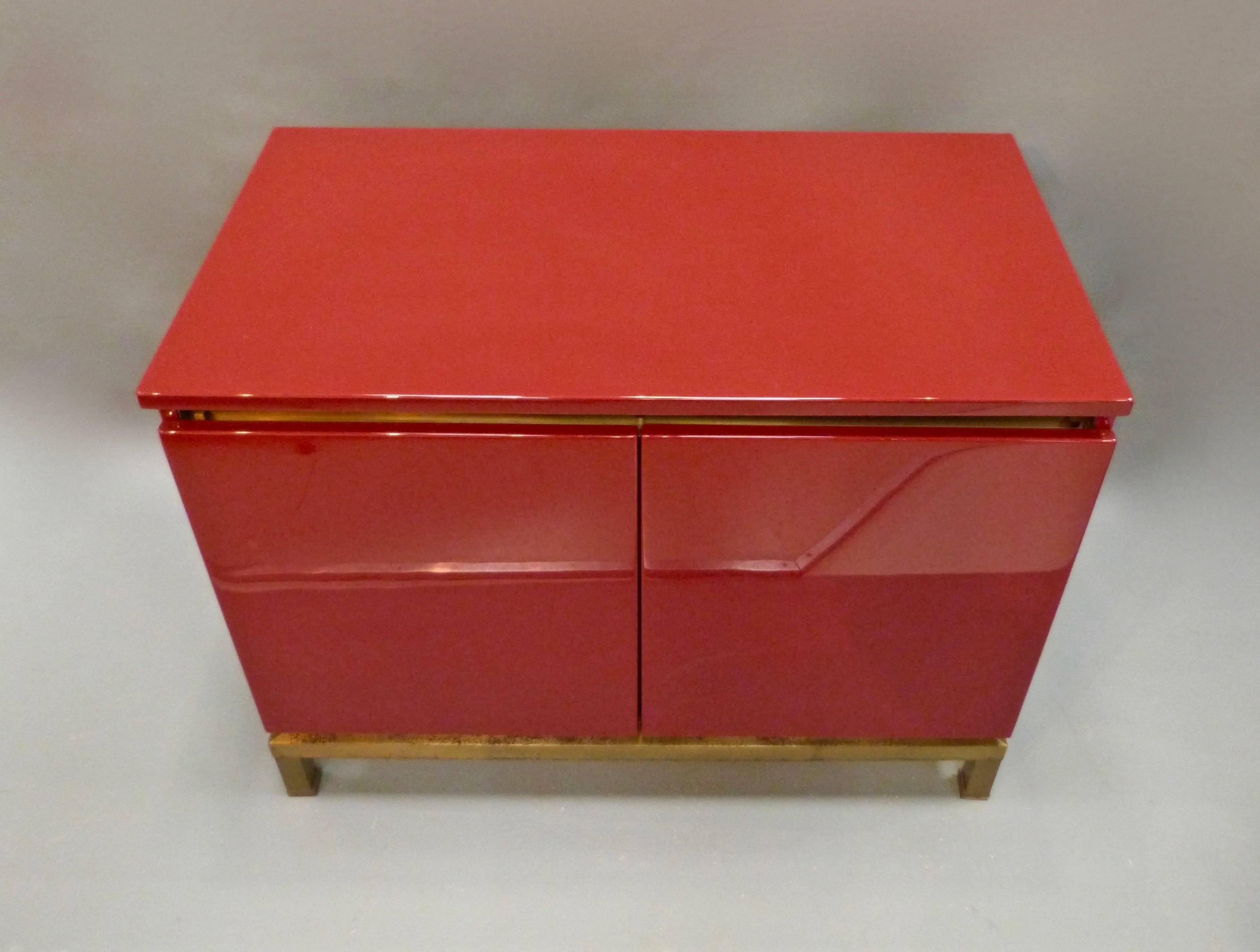 A stunning looking red lacquered two-door cabinet on a gilt metal stand by Guy Lefevre.