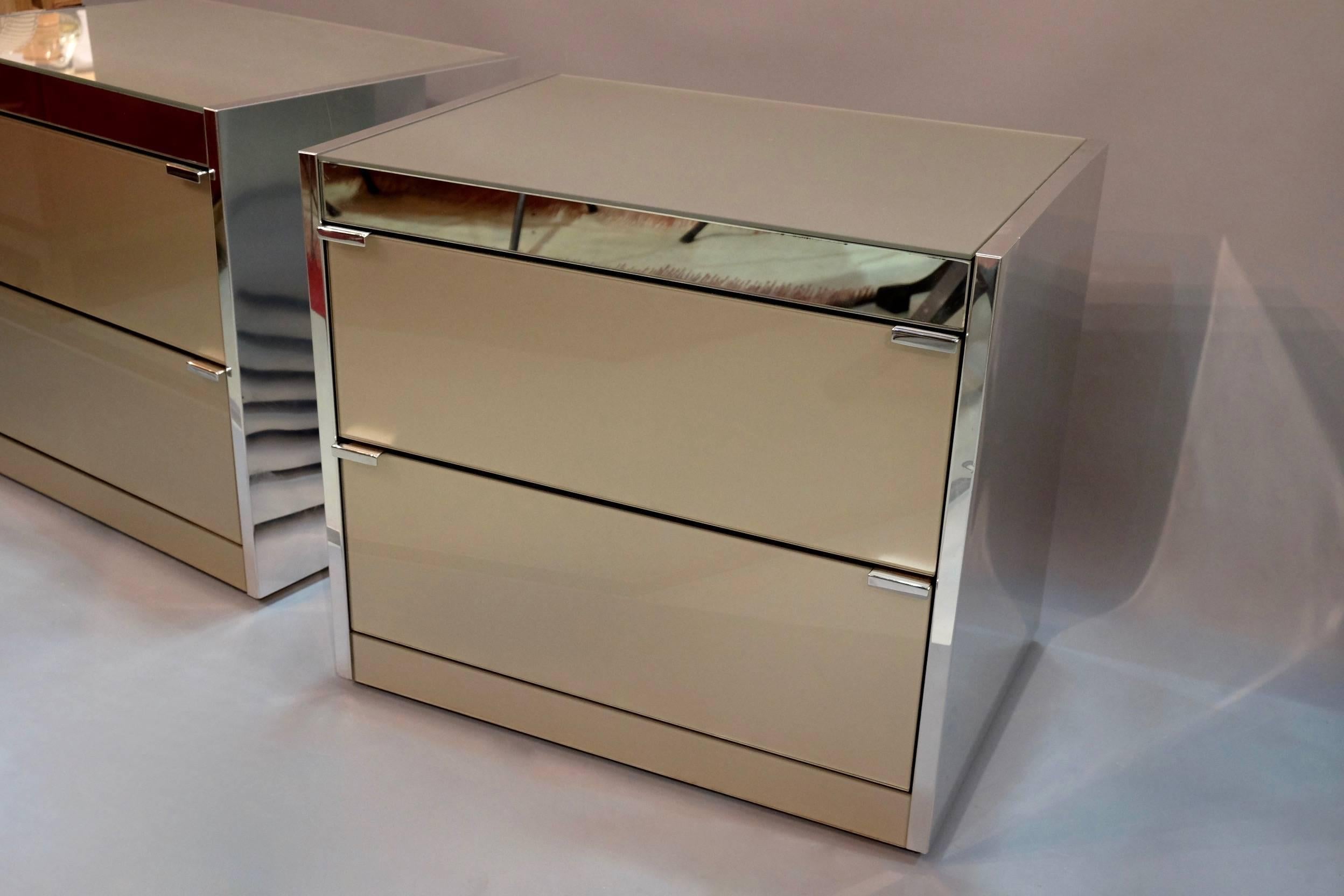 A good pair of American glass and polished nickel-plated two-drawer bedside tables by "ELLO".