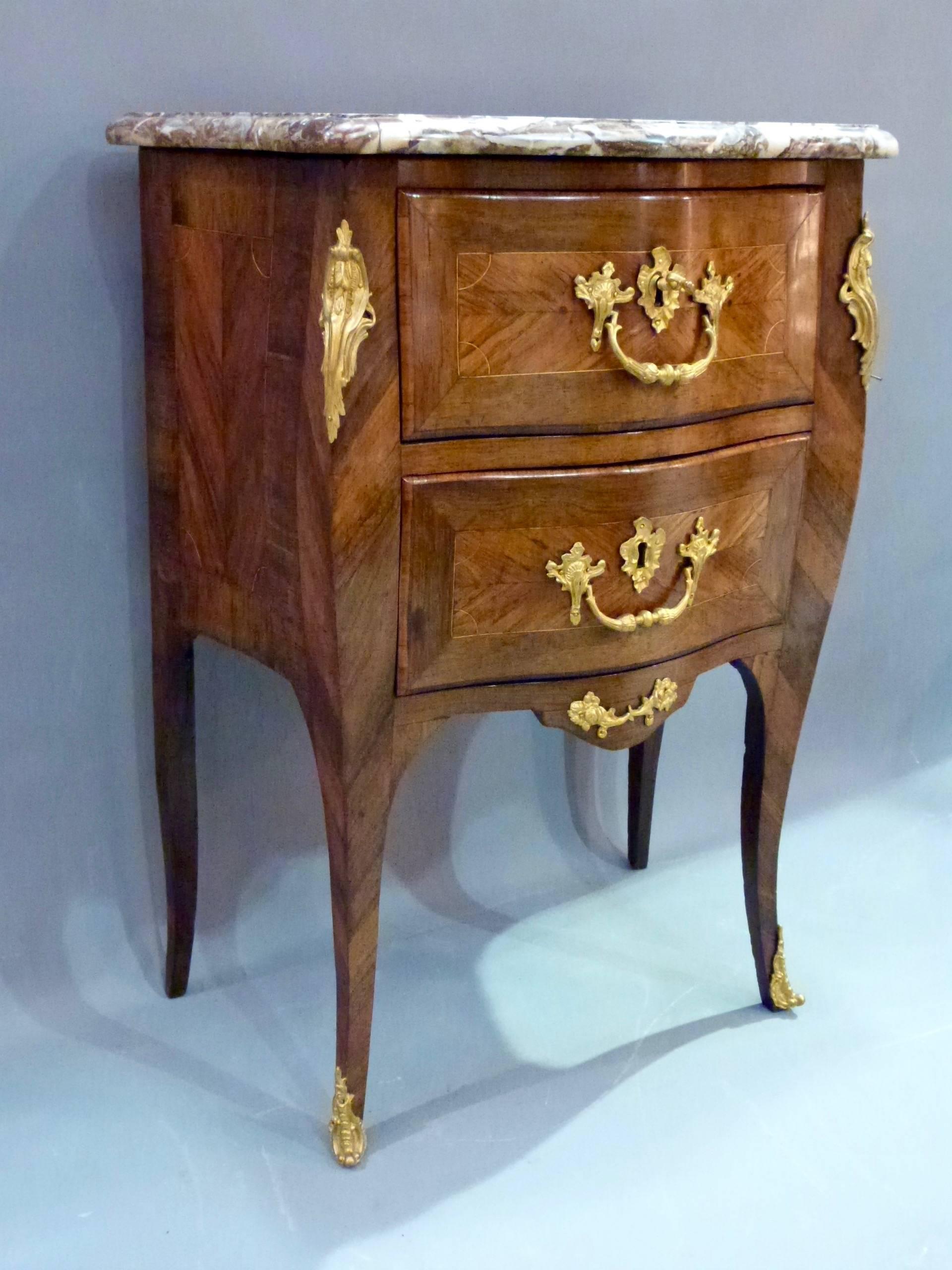 A Louis XV Petit commode by Jean Charles Ellaume. Stamped in two places I C Ellaume JUE. Serpentine form using rosewood and tulipwood. Two drawers with foliate cast gilt bronze mounts. Original key, circa 1760.
