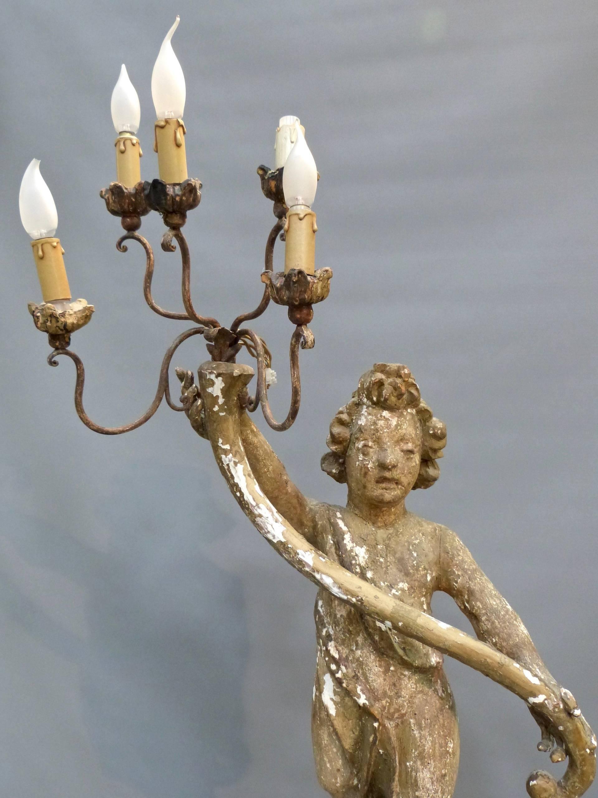 A rare and unrestored late 17th century Italian carved pine or limewood floor standing candelabra. It has its original candle arms which have been electrified at some stage. The Piece although it is in its original condition it is sound in