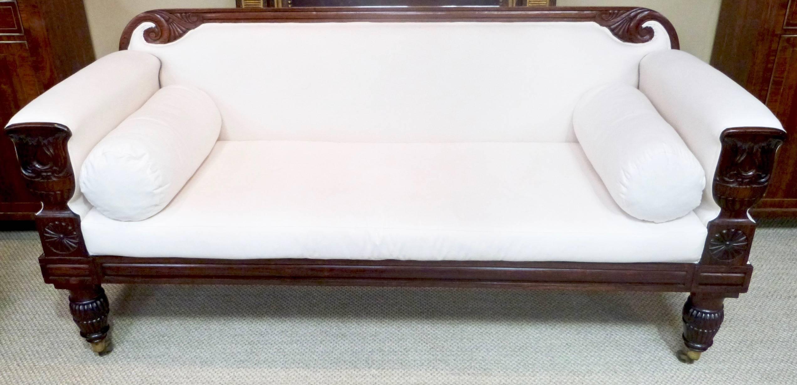 A Regency rosewood framed sofa on turned lobed front legs with brass castors.
