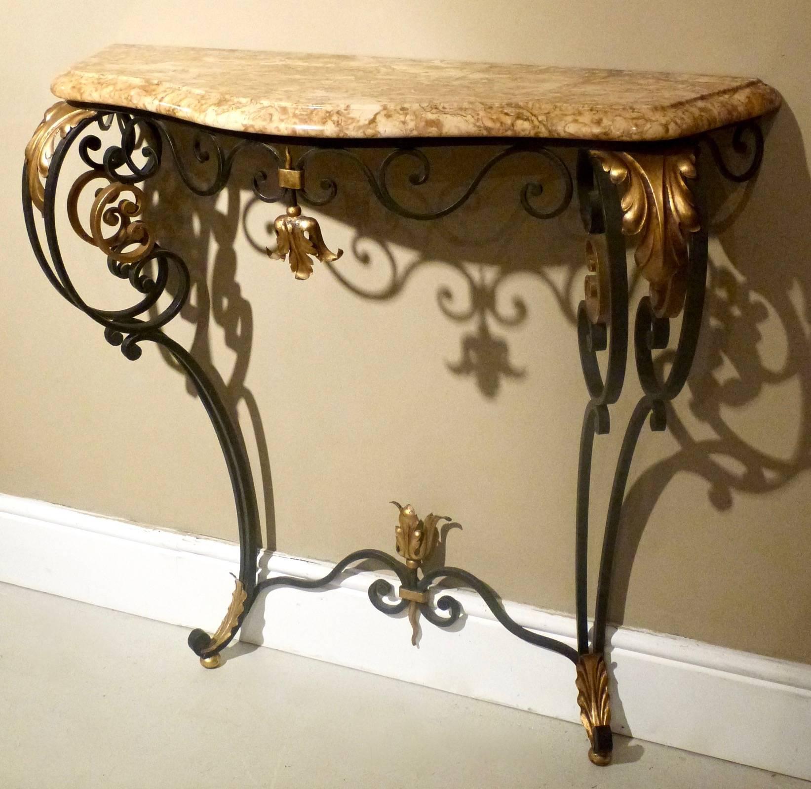 A pair of early to mid-20th century French wrought iron console tables with serpentine marble tops.