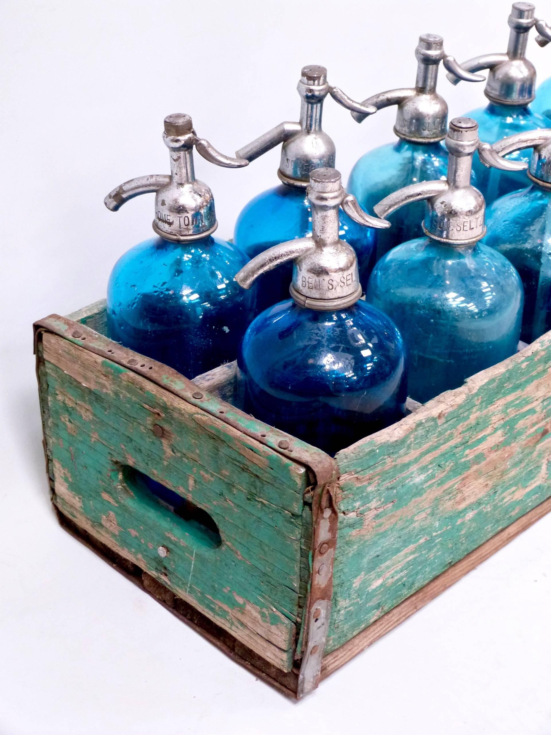 A collection of ten French 20th century antique blue seltzer siphon bottles, in a wooden crate, circa 1950.