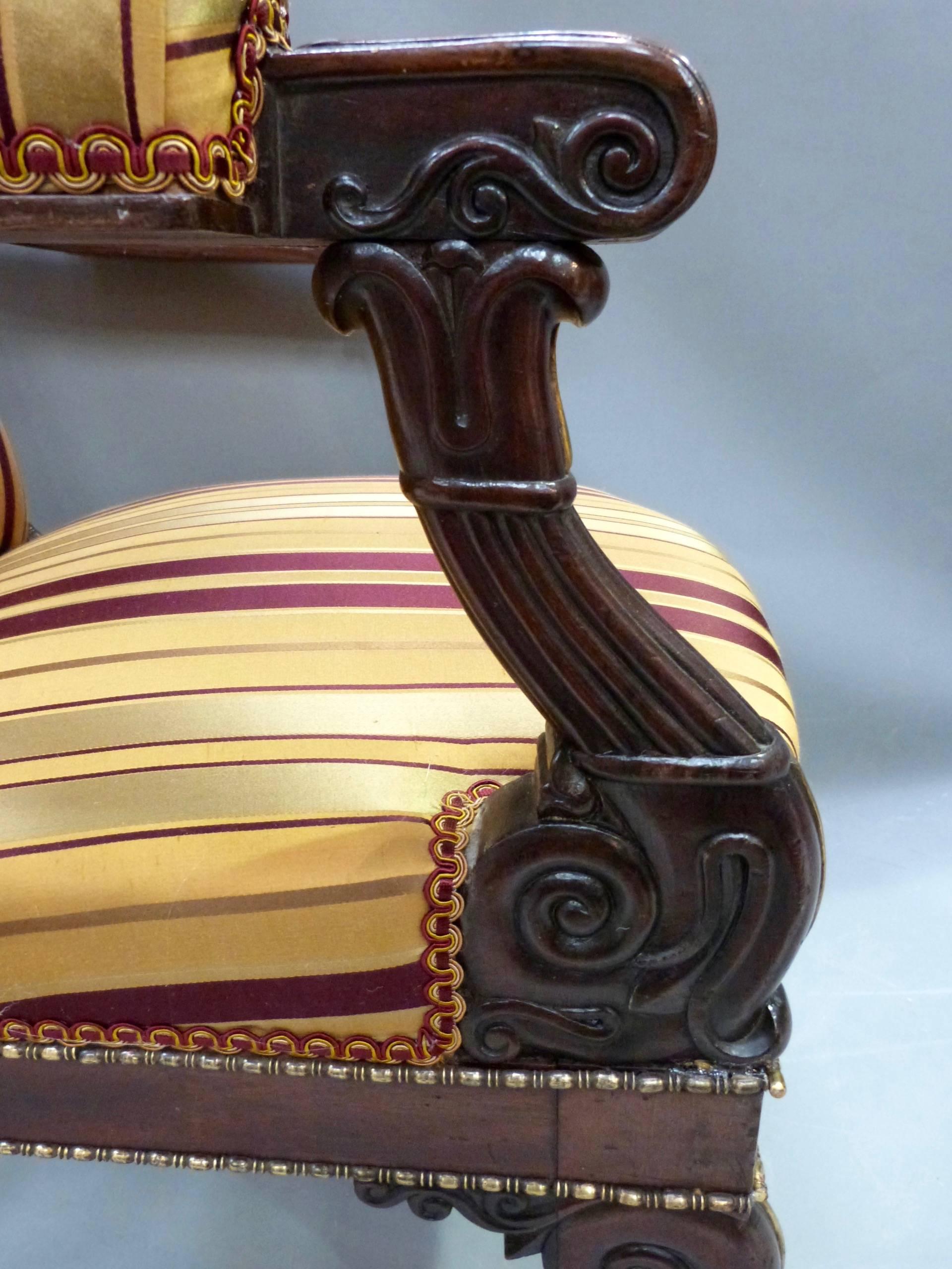 A pair of 19th century French Empire mahogany and brass inlaid elbow chairs.