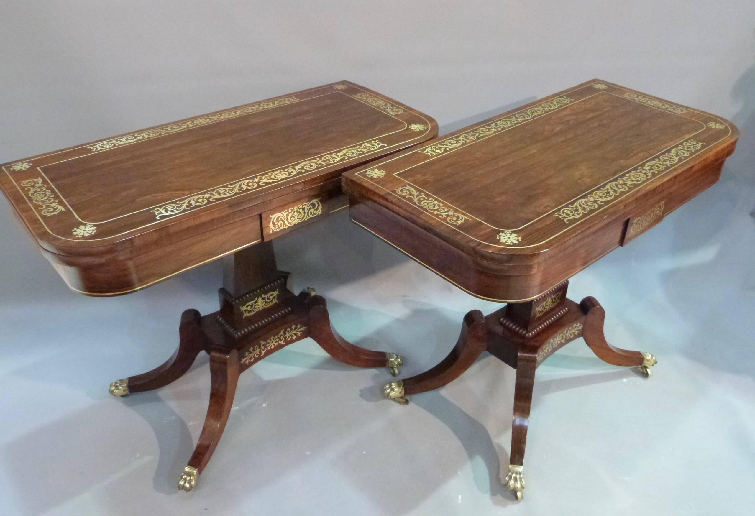 A pair of fine quality Regency rosewood and brass inlaid fold over card tables.