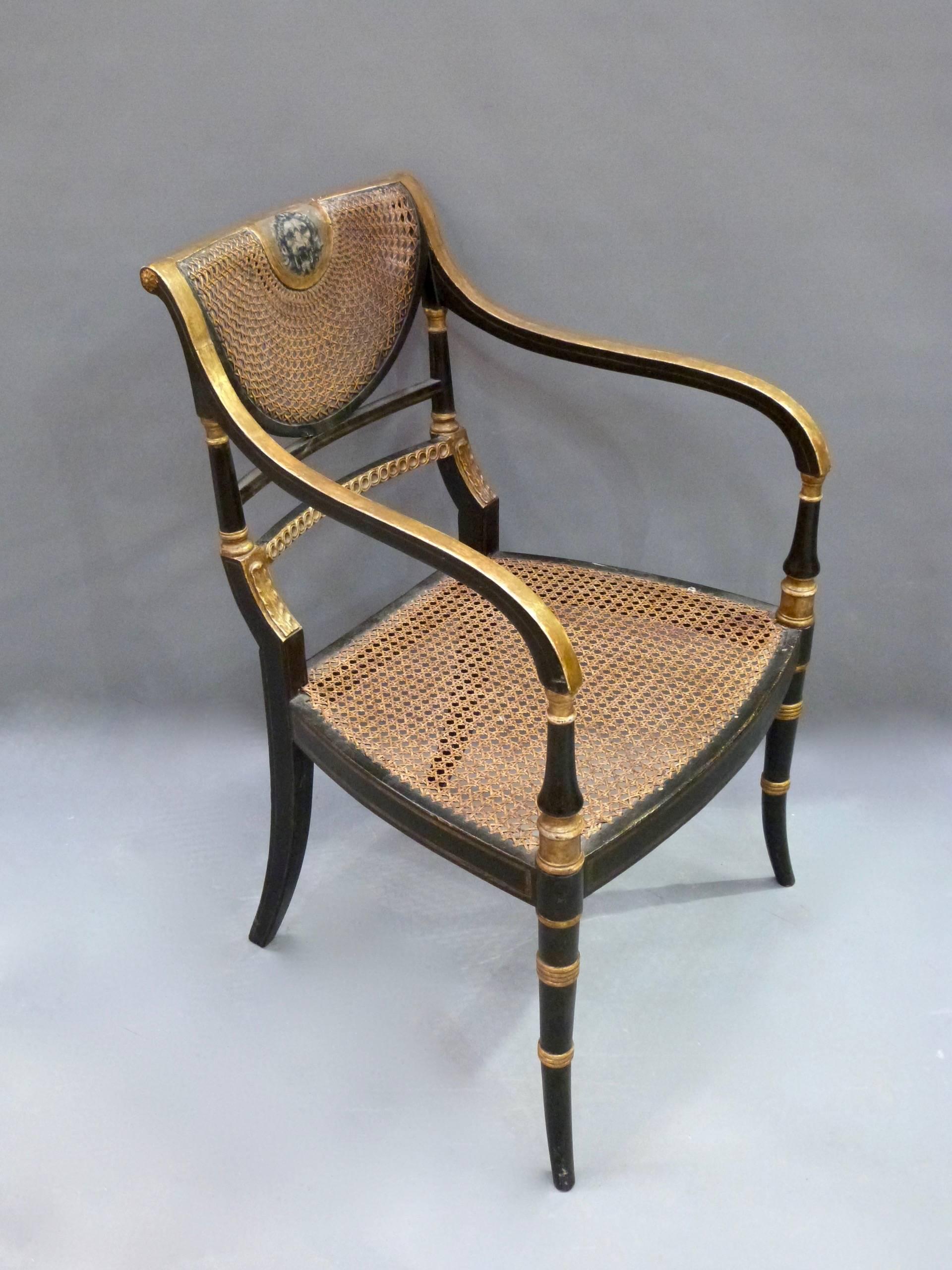 A superb pair of Regency ebonized and parcel-gilt carver chairs with Lions head painted decoration and original canning.