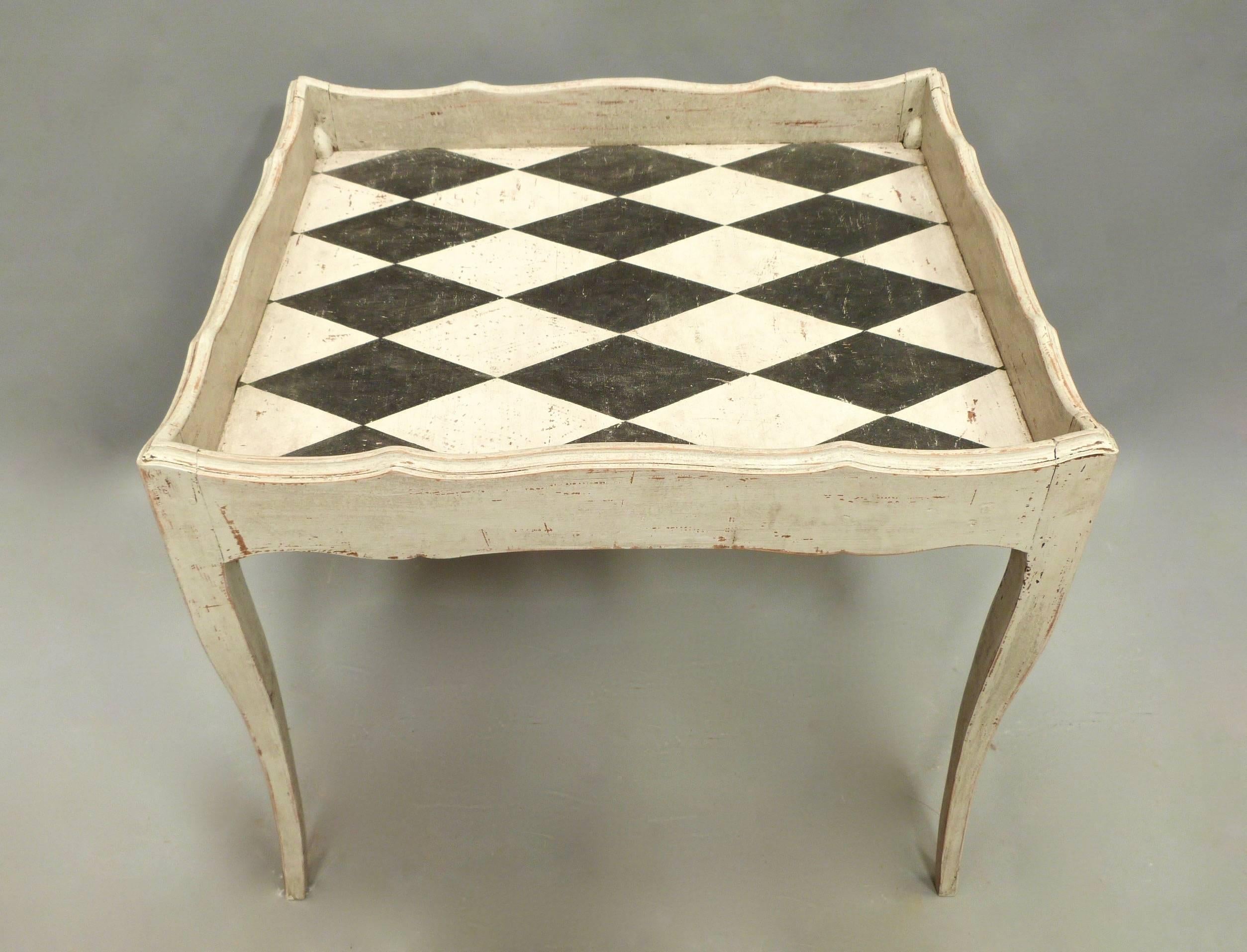 An early 20th century French painted wine table with later Harlequin painted top.
