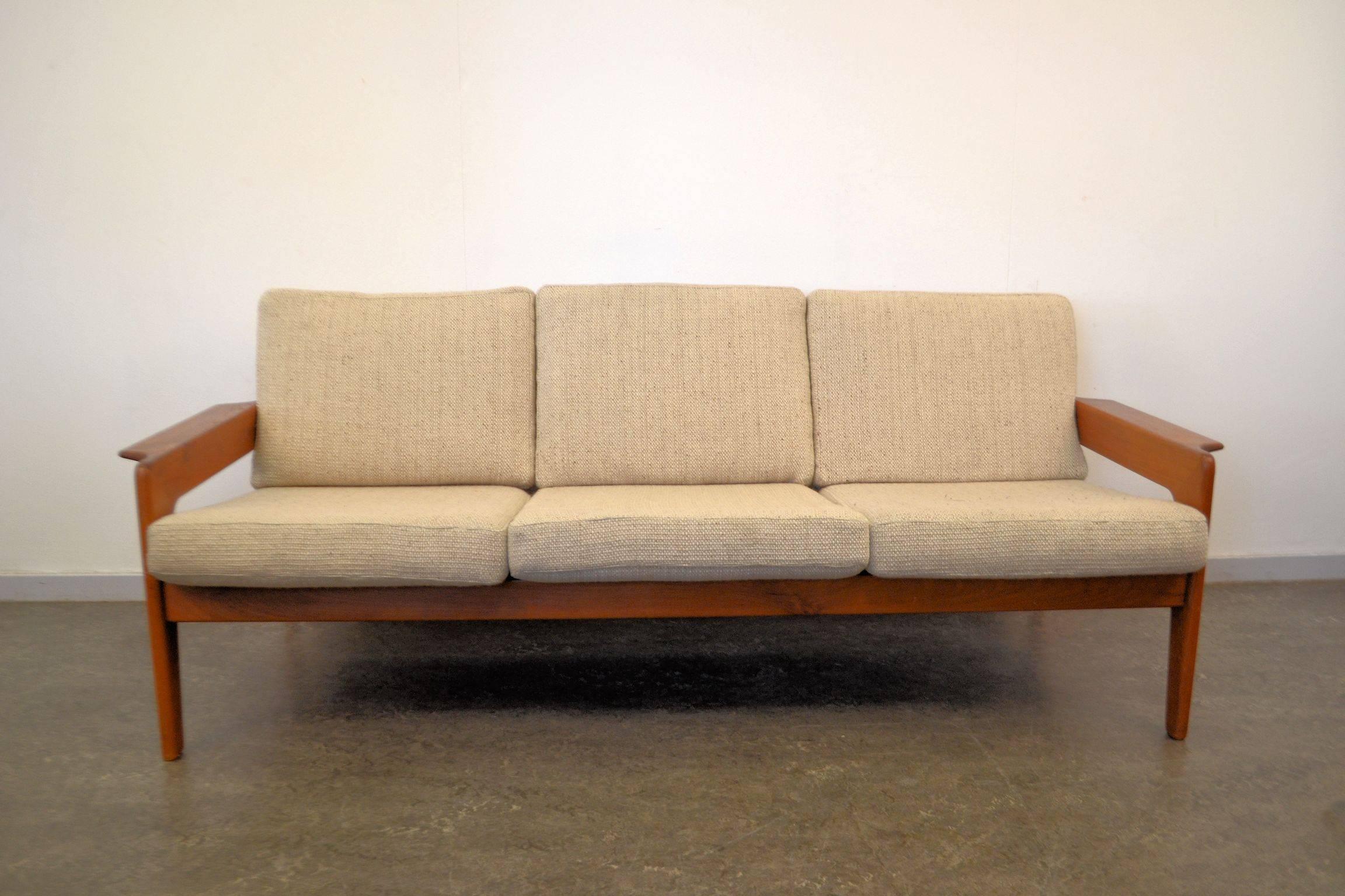 Danish modern three-seat sofa designed by Danish designer Arne Wahl Iversen. The sofa features a solid teak frame and most likely its original creme wool upholstery. We’ve had the webbing replaced to ensure many years of seating comfort. Super