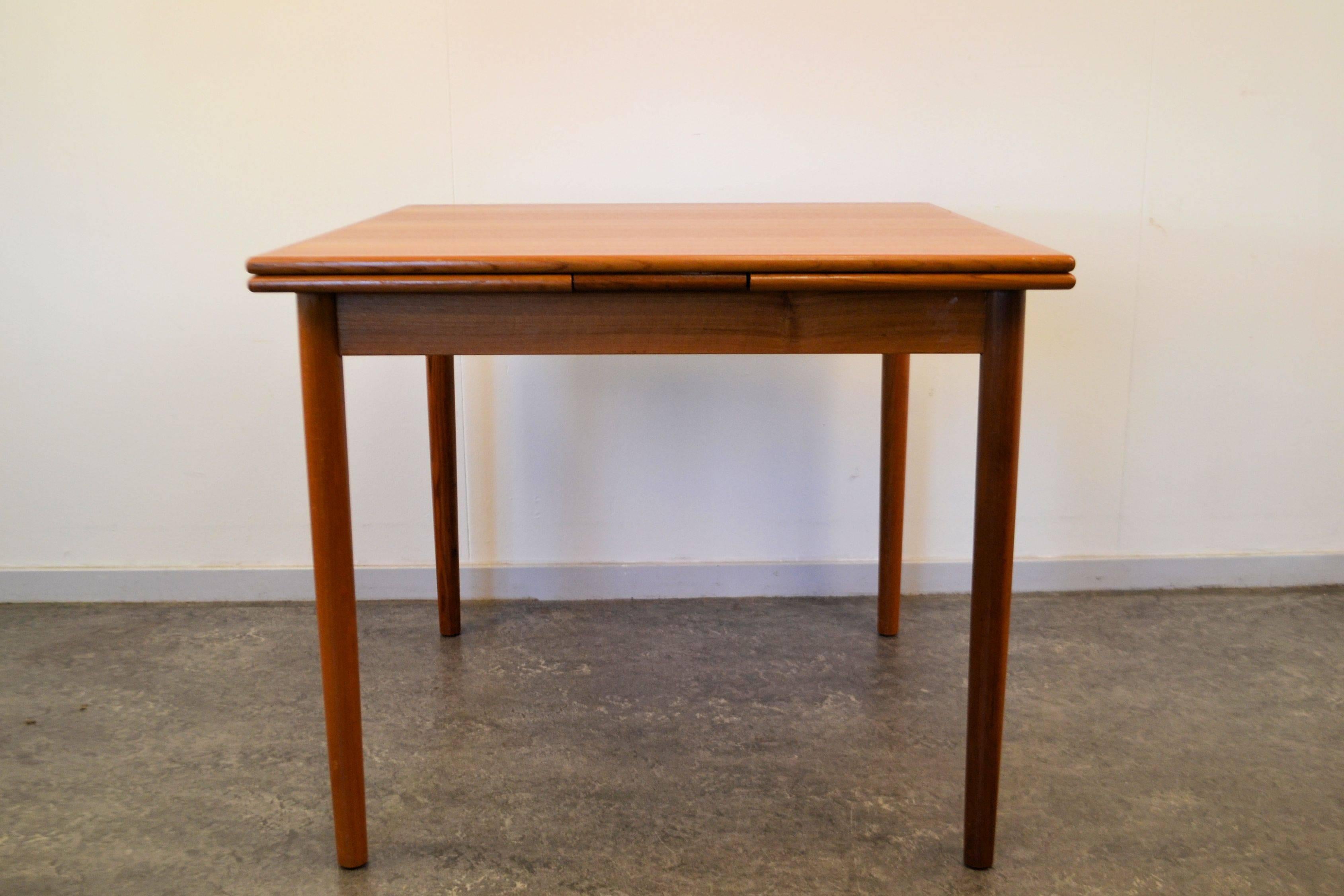 Mid-Century Modern square teak dining table. This table has been produced in Denmark (sticker under table) during the 1960s and has two extension leaves, to make the table a total length of 156 cm.