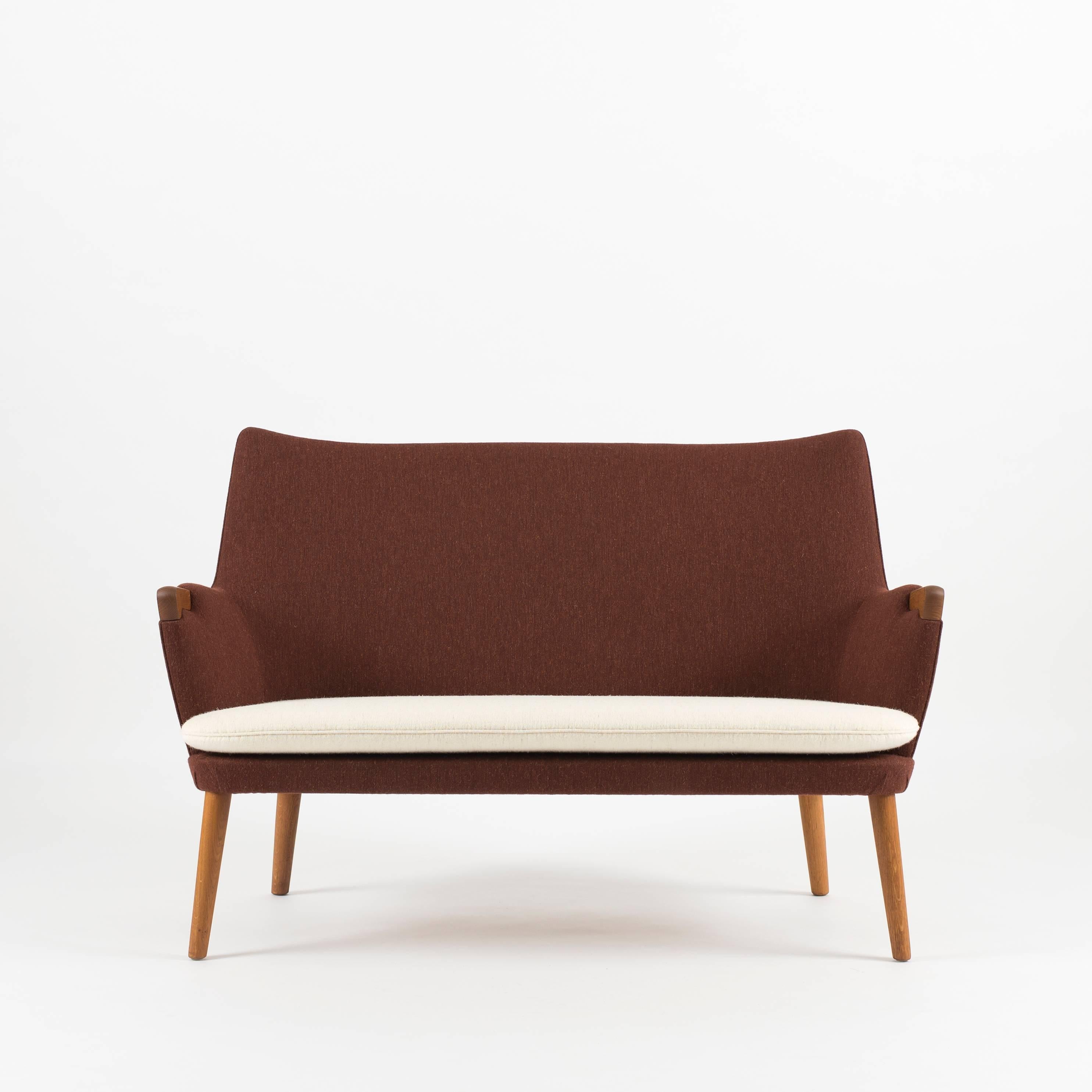 Hans J. Wegner two-seat sofa in oak and wool upholstery, model AP20. Executed by AP Stolen, Denmark.
   