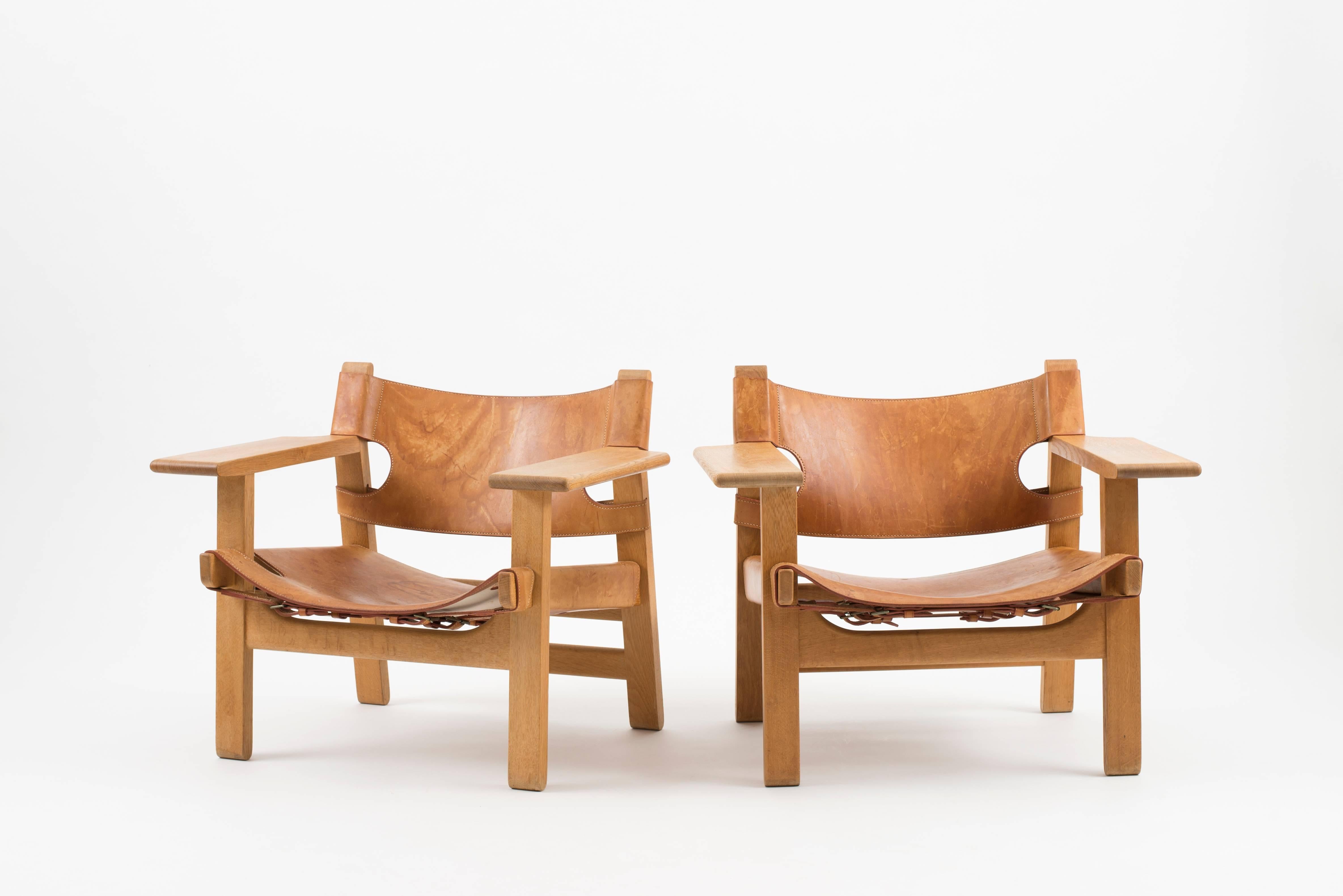 A pair of Spanish Chairs by Børge Mogensen. Executed by Fredericia Furniture.

Oak and vegetable tanned leather. Reverse with paper labels Fredericia Furniture, Denmark