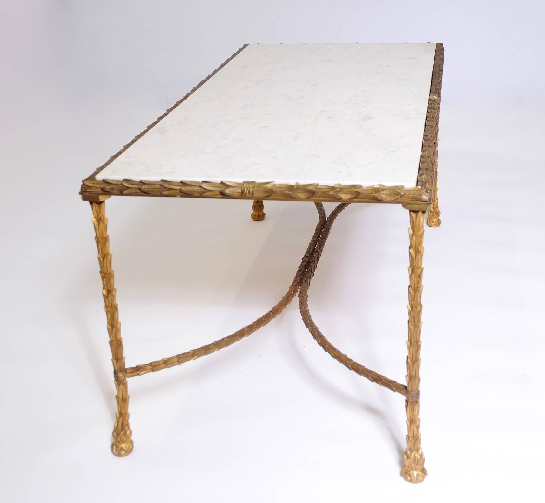 Coffee table by Maison Baguès in gilt bronze, white original marble top.

Since its establishment in 1860, the Maison Baguès has been an emblem of French sophistication in luxury lighting design. Each piece the firm makes is hand assembled using