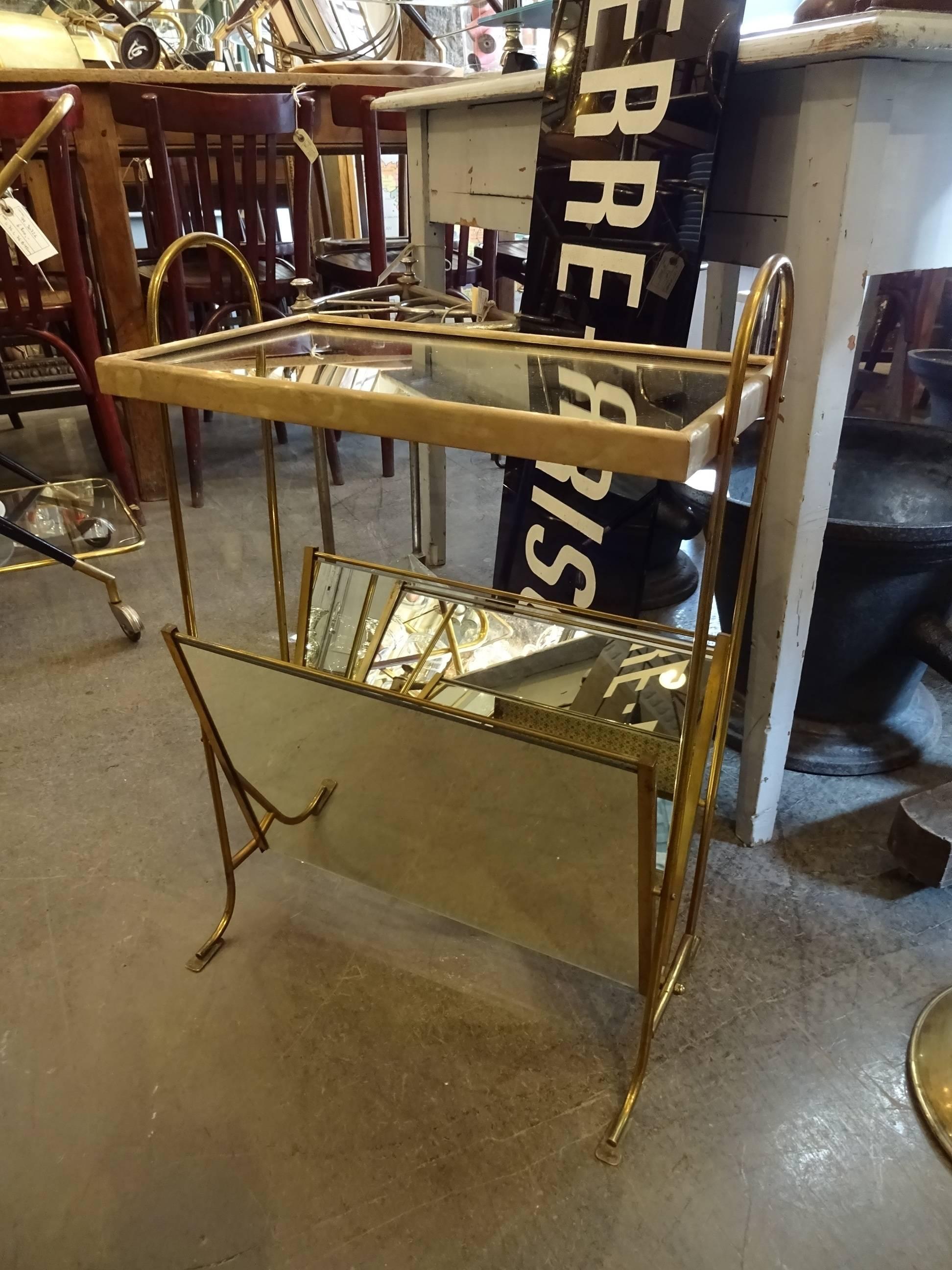 Elegant French newspaper rack / side table in brass with a small mirrored tray and a holder for newspapers or magazines. A practical and eye-catching side table.