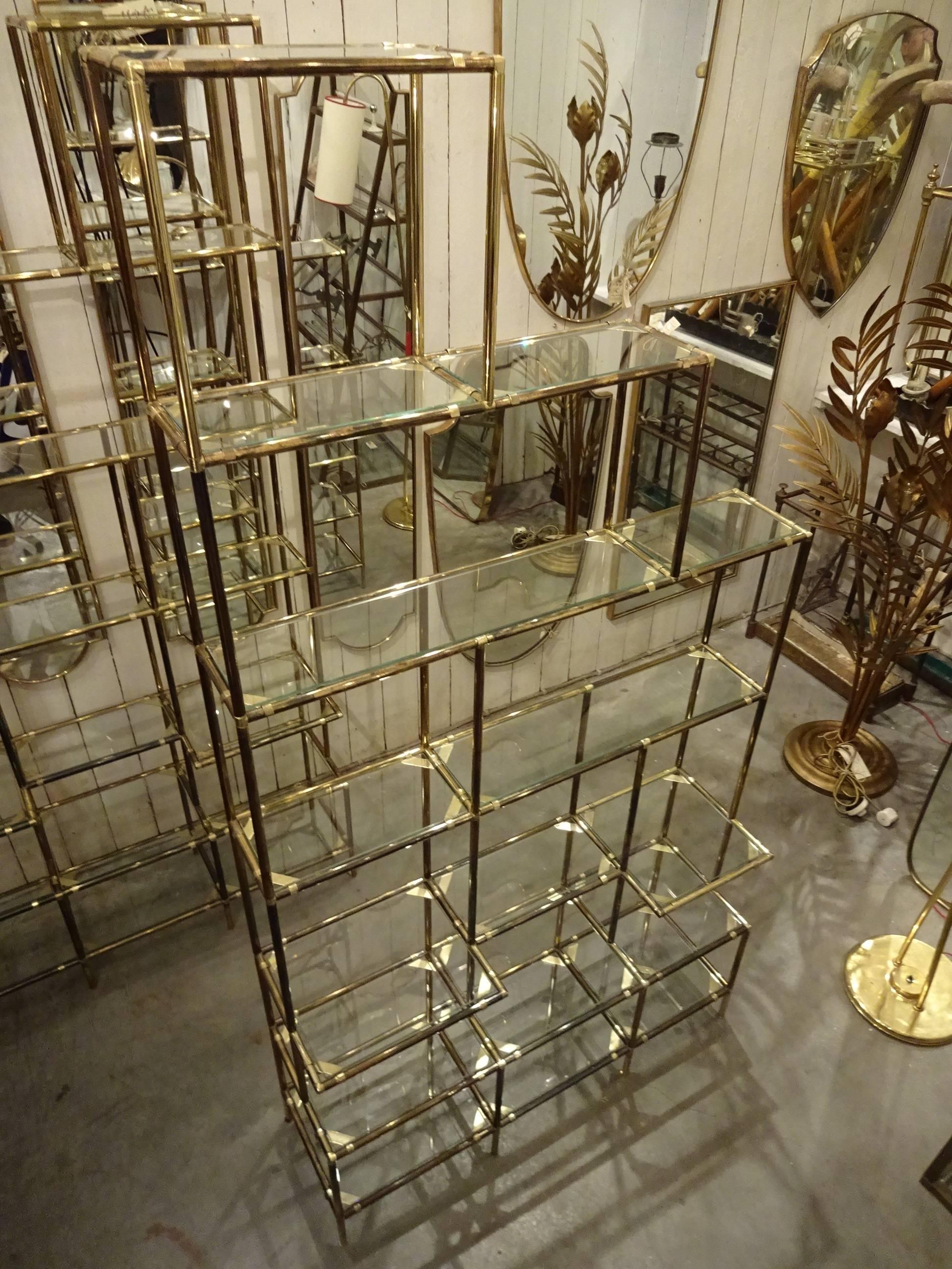 An utterly fantastic and unique pair of vintage Italian brass and glass shelving units with different depths, giving it an almost three-dimensional look. A true sculpture in itself. Originally from a shoe store in Milan from the 1950s.