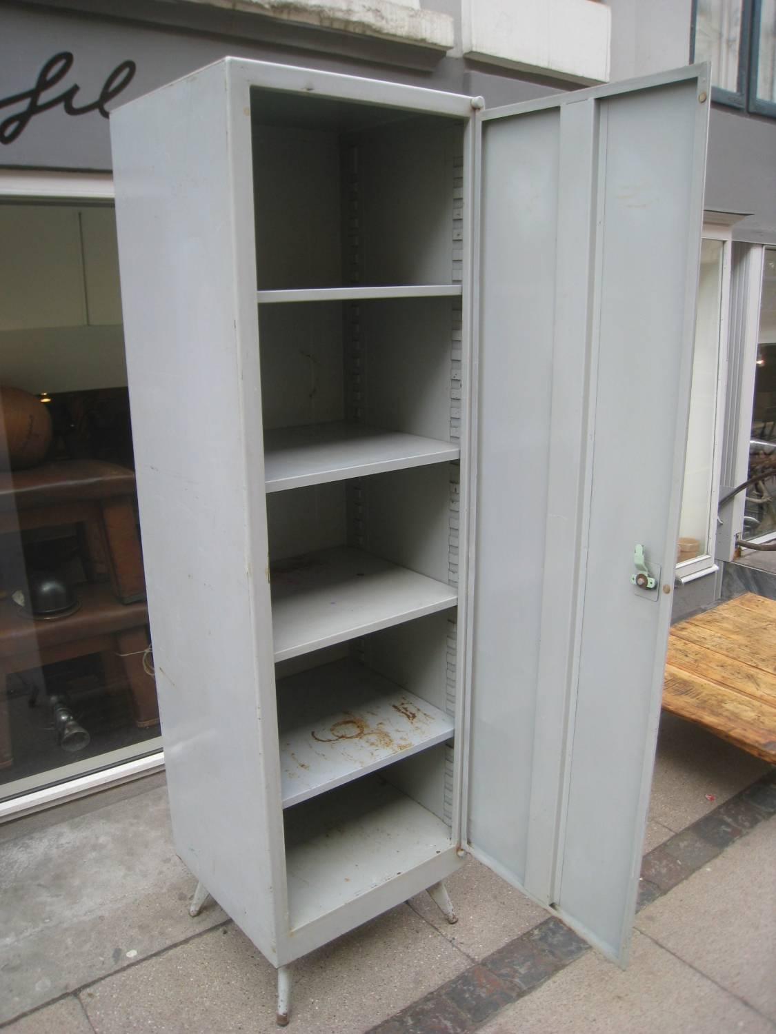 Rare vintage Tolix metal cabinet. Note the typical Tolix slanted legs. Original grey paint. Four movable shelves inside.