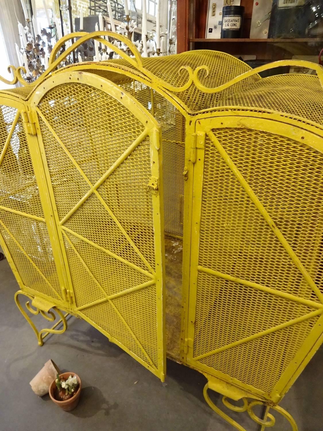 Completely extraordinary vintage French birdcage – aviary/voliere size. This fantastic piece is hand made in cast iron, and painted a glorious sunny yellow. Superb details. Comes complete with trapeze, feed and water troughs. Would make a wonderful