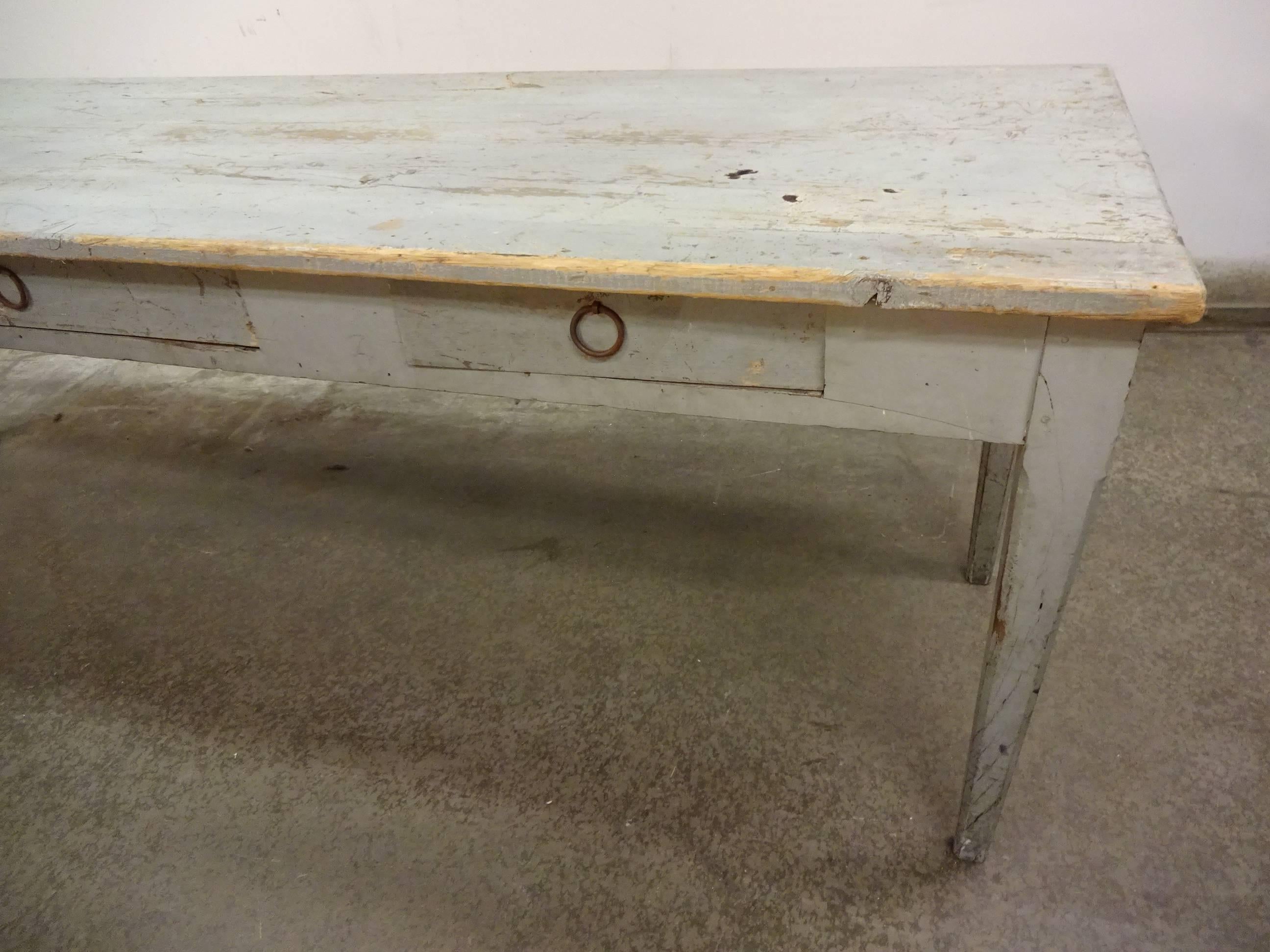 Gorgeous old Italian refectory table painted in a delicate grey-blue shade. The table has three drawers in the front apron and an absolutely fabulous patina.

 