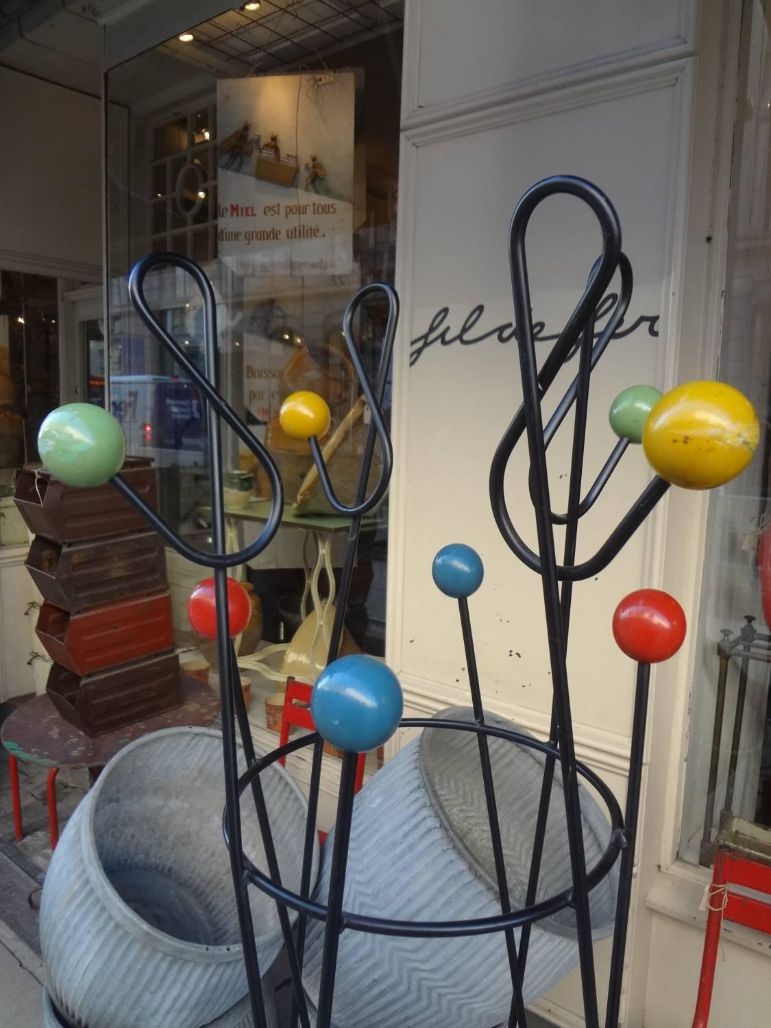 Fabulous vintage coat stand from the 1950s, designed by Roger Feraud. Made of cast iron painted black, with coloured wooden balls. Called ‘Clé de Sol’ (Sun Key) or Perroquet (Parrot). Fantastic cool piece. Great patina.