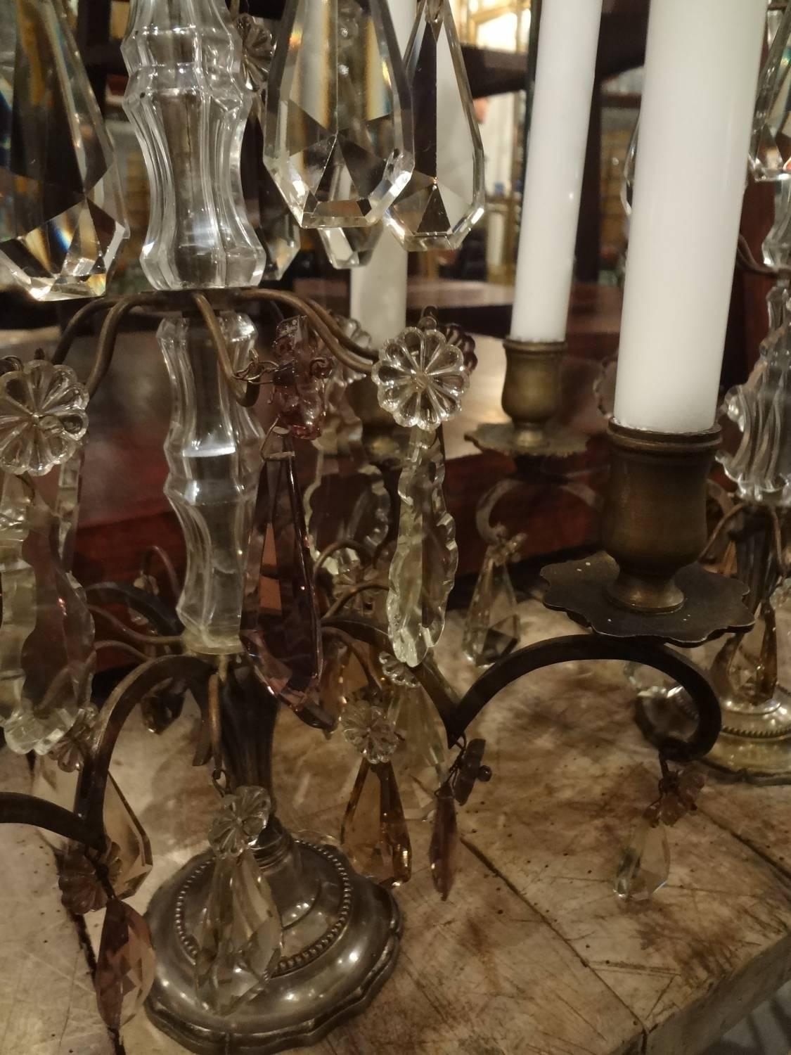 A sumptuously beautiful French candelabra pair (girandoles). Rare size. Cast in bronze, with stunning clear, smokey and lilac prisms. Hold four candles each.
