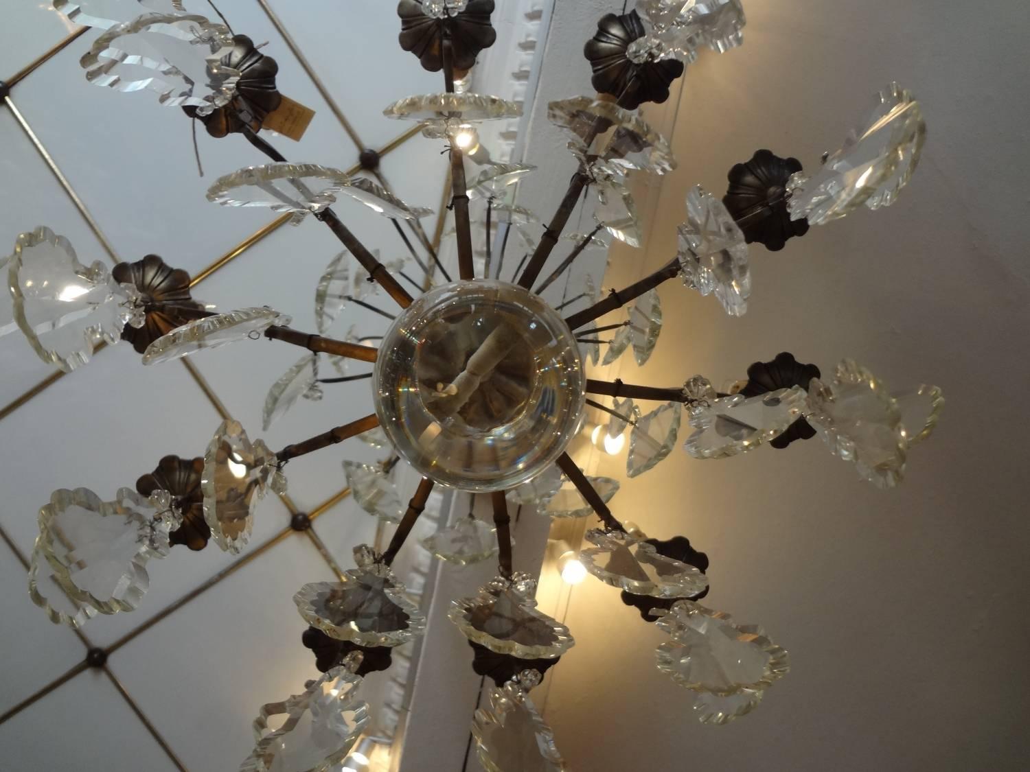 Antique French prism filled chandelier with a dark bronze patina. Wonderfully ornamental flat leaf glass prisms, in different sizes. Holds ten candle shaped light bulbs.