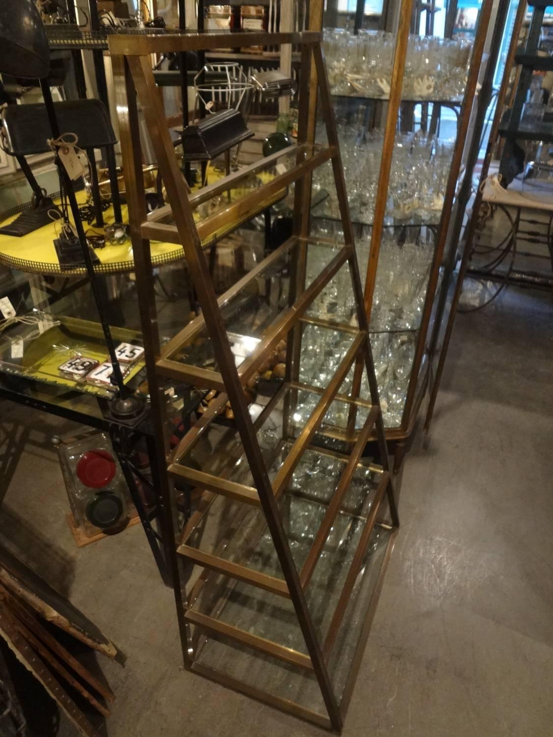 Cool vintage French shelving unit made of brass, with glass shelving. Elegant shape and sleek design.