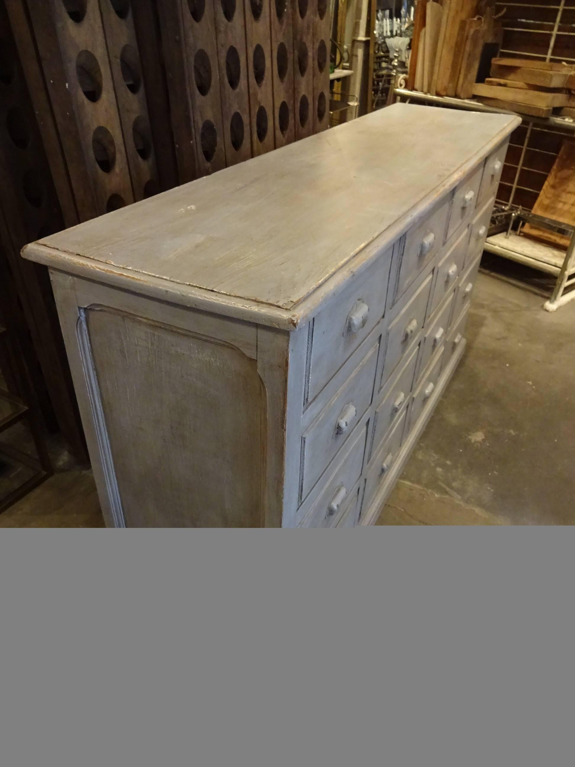 Very handsome wooden chest of drawers from France, with elegant gray look. This piece has 16 large drawers, each with beautiful iron grips. An ideal piece of furniture for storage, or alternatively as a lovely console table.

  