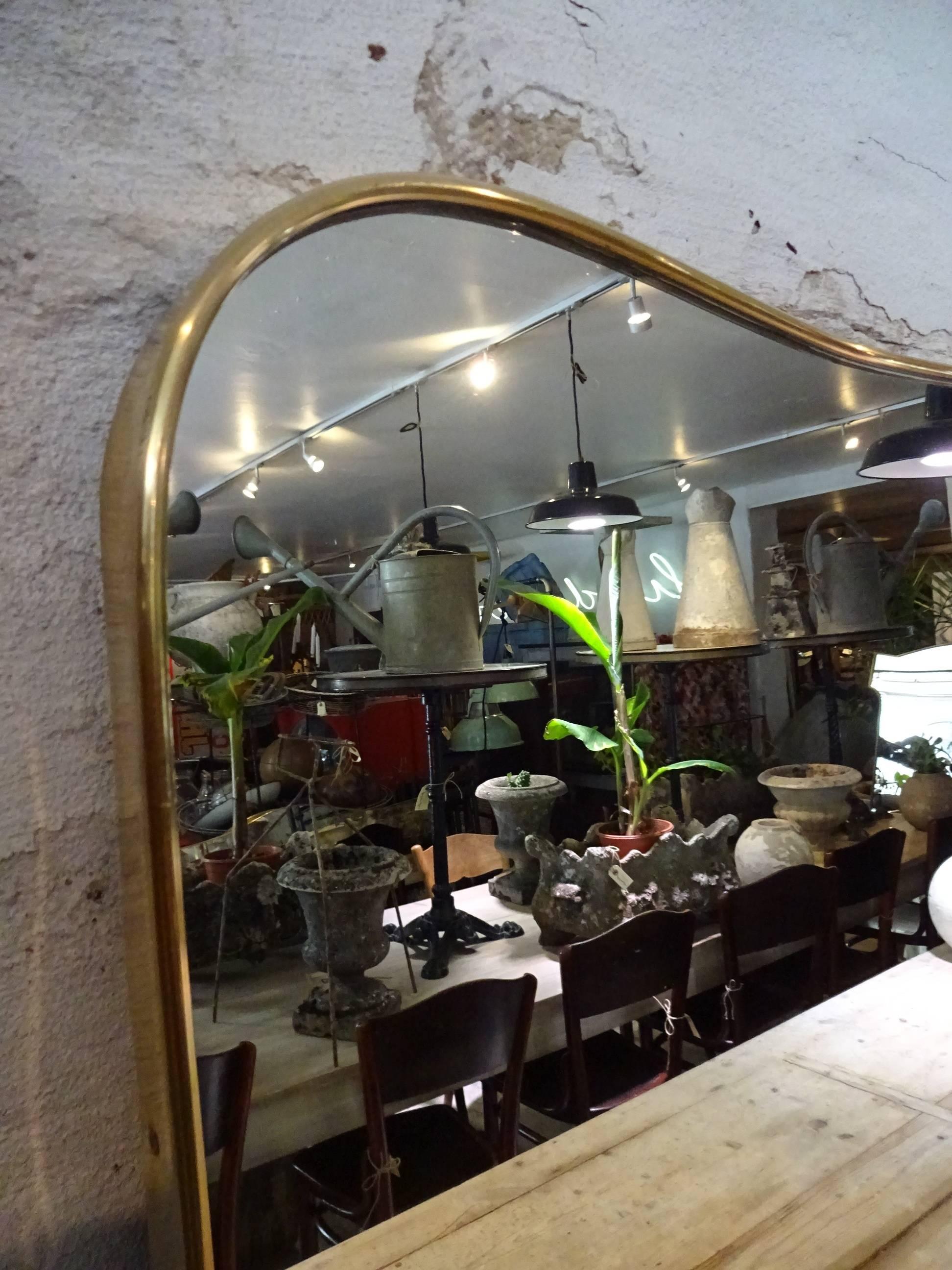 Huge and beautiful Mid-Century Italian brass mirror in a simple and elegant frame. Gorgeous shape.

