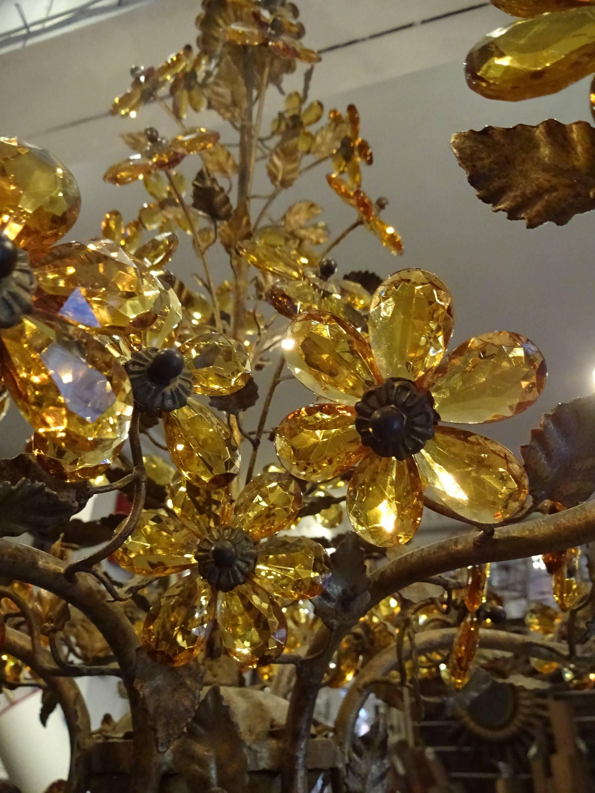 Gorgeous vintage French gilt metal chandelier with stunning amber colored cut floral shaped prisms. Has a divine sheen, and holds six lights.
 
 