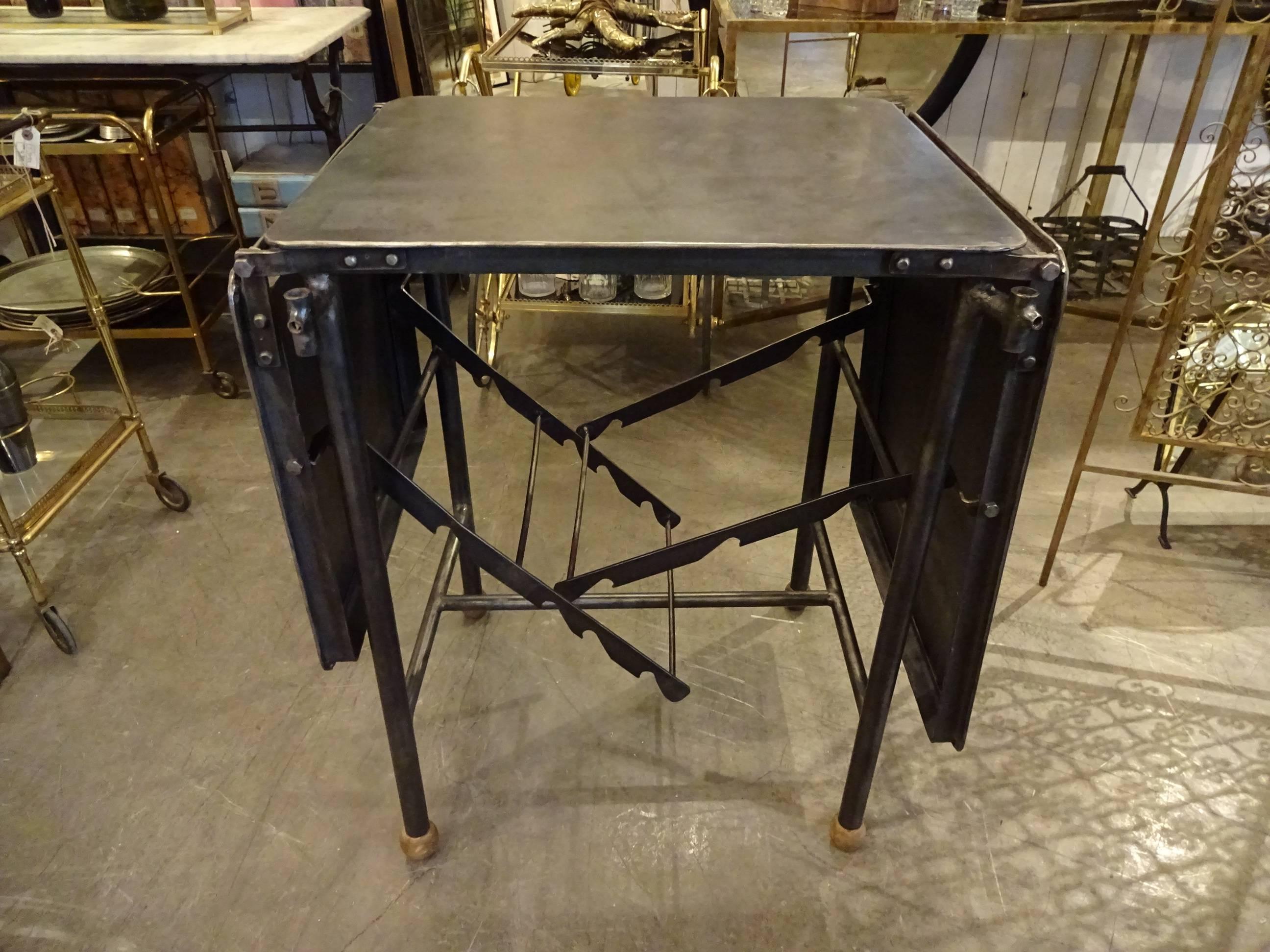 Old French Industrial metal table in a raw desiccated and polished metal surface. The table has one flap at each end, which can be folded down separately.

Measures: H 80 x L 168 x W 51 cm.