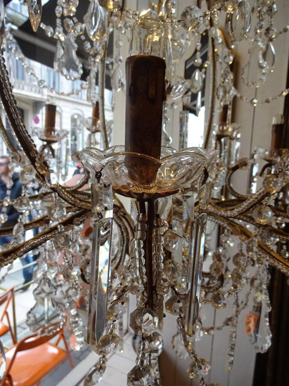 Glorious and large vintage French chandelier, circa 1920s, with a gilt frame and dozens of glass prisms leaves and beading work. 24-light sources in two levels. Wonderful piece and a work of art in its own right.

Measures: Height 145 x diameter