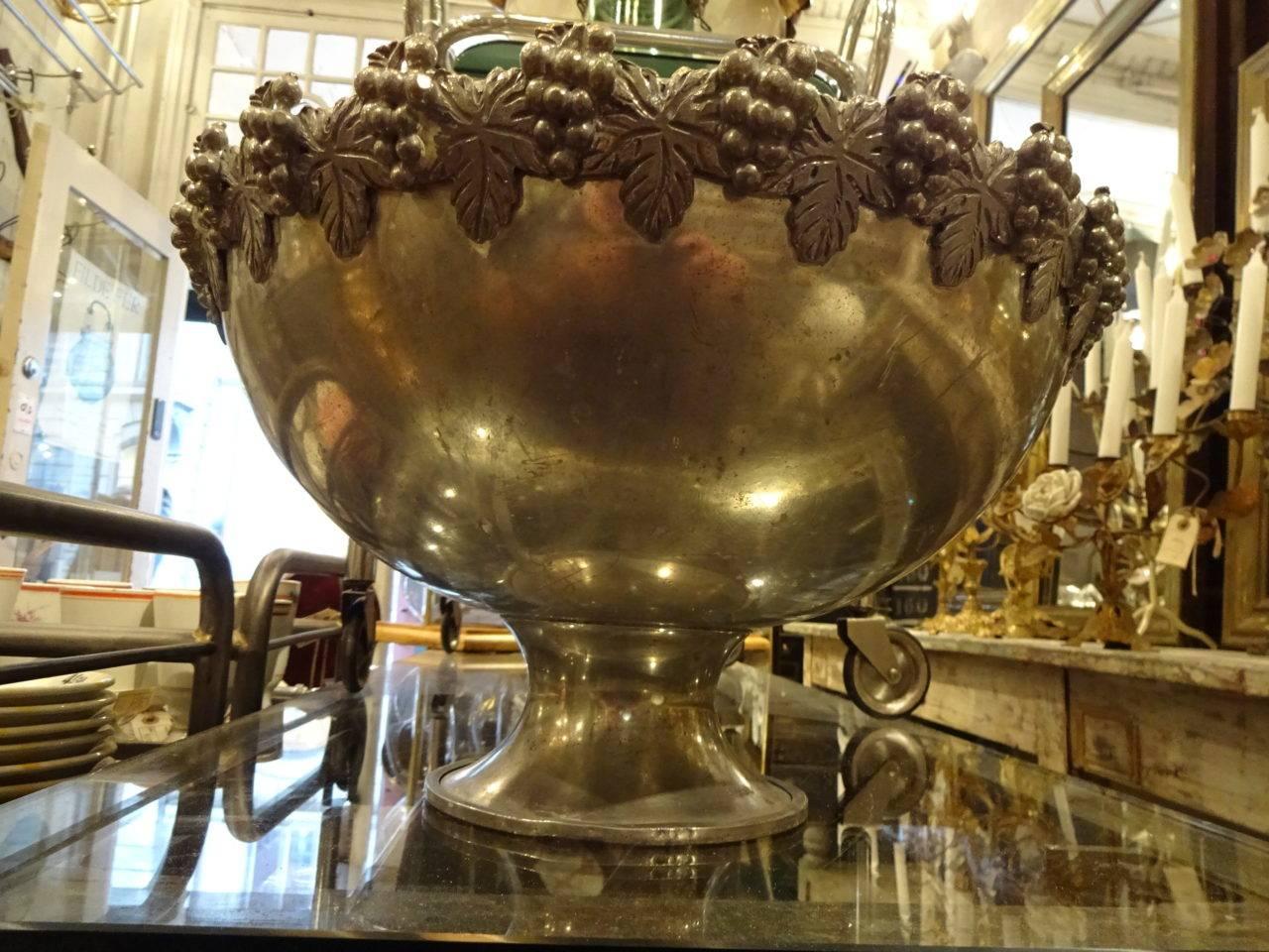 Old French champagne cooler in tin with amazing patina and ornaments of grapes and wine leaves along the edge of the cooler.
The cooler is lifted beautifully on foot and can accommodate 4-6 champagne bottles.

Measures: H 24 x diameter 41 cm.