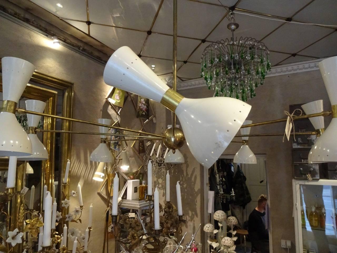 Gigantic and fabulously classic ceiling light, in 1950s Italian novo style. Stunning brass frame and white metal shades, with eight movable lampshades and light sources at both ends. Wonderful iconic and eye catching piece.

Measures: height 120 x