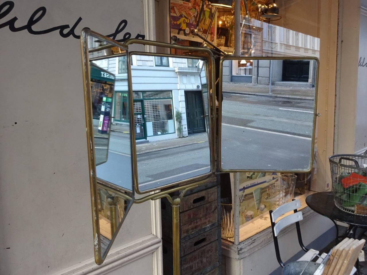 Fantastic and rare shaving mirror on a brass stand. Equipped with a gorgeous brass edged marble top. The mirror has three panels, the central one can be adjusted and tilted. See images for clad backing decoration.