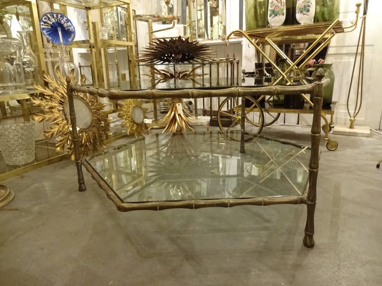 Gorgeous vintage six-sided brass framed three-legged coffee table. The frame is formed as bamboo and the table top and shelf underneath are in solid quality 6 sided glass. Super detail. Eye-catching. Conversation piece.

A rare, stylish and