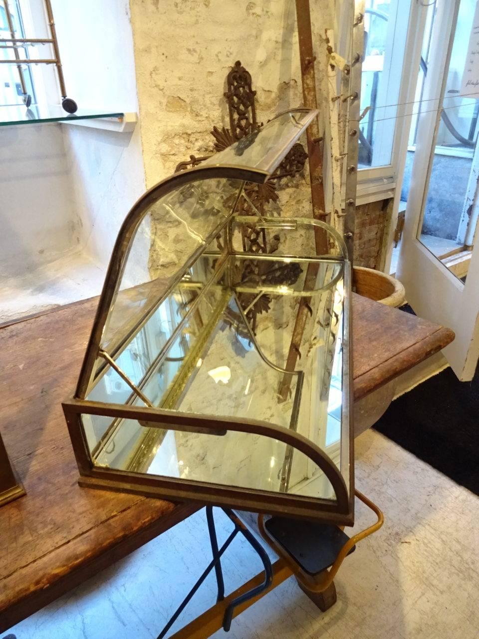 Vintage jewellery display case from a French jewellery boutique. Made of brass, with mirrored glass, this display item also has the most beautiful curved glass front.