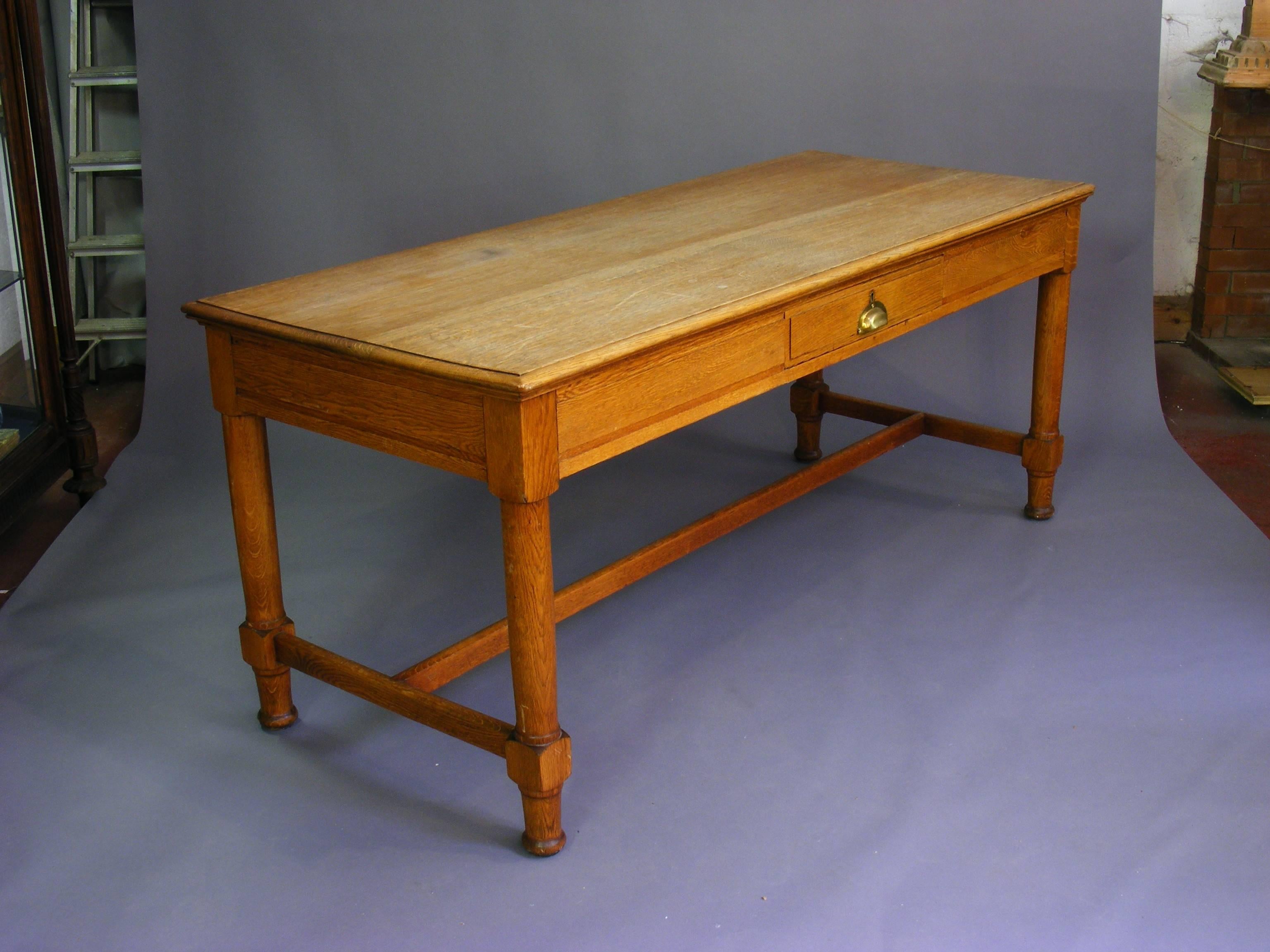 A 19th century oak farmhouse hall table with four gun barrel legs united with an H shaped stretcher.