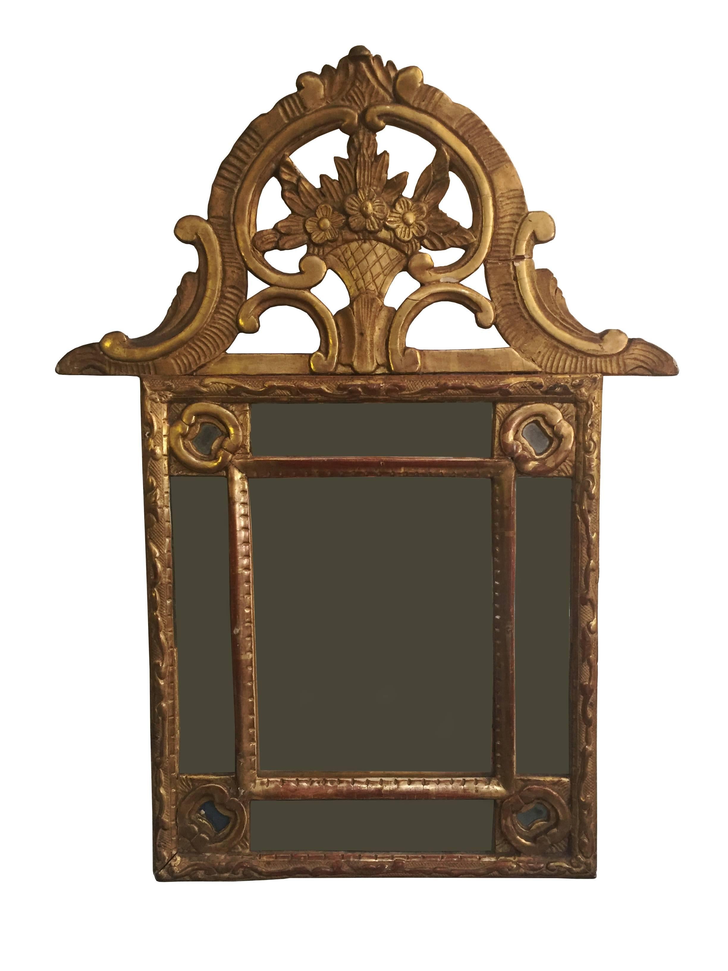 Antique 18th Century French wood carved and gilt mirror

The rectangular frame is bordered with original silver plate glass with beautifully carved edging. The pediment contained and bouquet of flowers all with original gilding in good