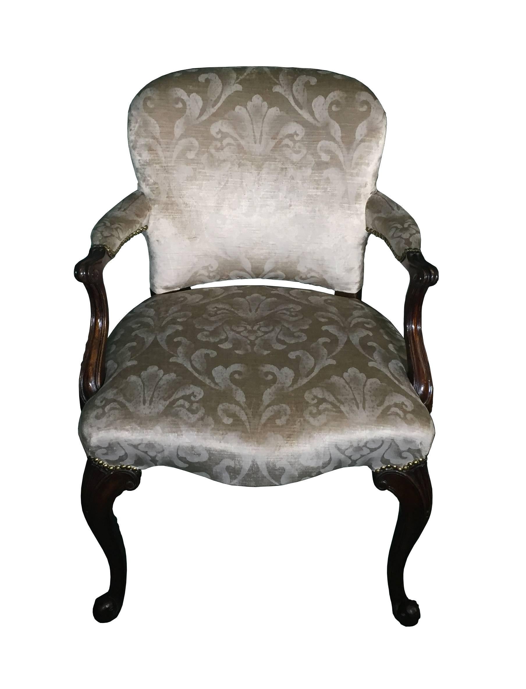 Antique mahogany chairs Chippendale revival with beautifully scrolled shaped and fluted arms. These chairs have been recently re-upholstered in a floral velvet damask. The seat of serpentine shape, raised upon carved cabriole legs with shell motif,