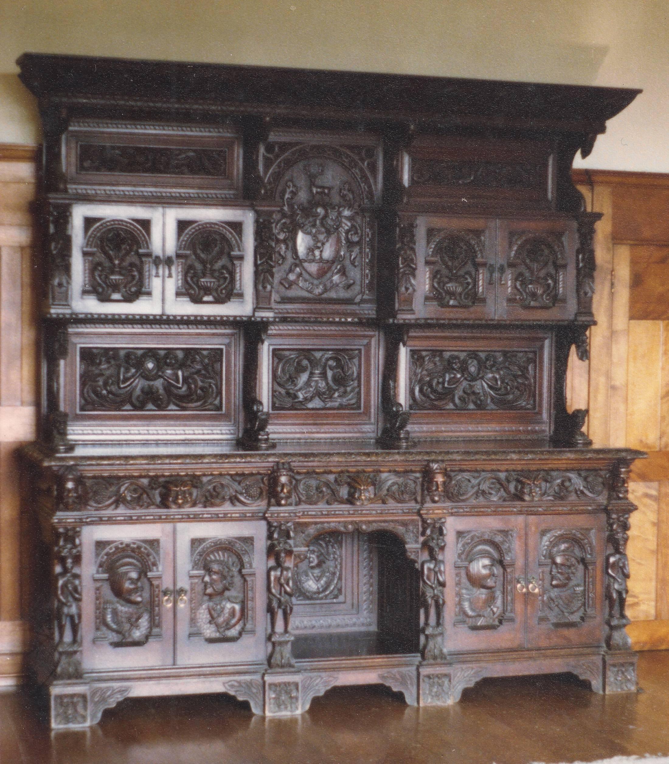 The McCorquodale crest and motto "Vivat Rex" prominently adorning the principal panel, between the two upper cupboards. The four lower doors display Scottish clansmen with a portrait of an unarmed figure, within the "kneehole" in