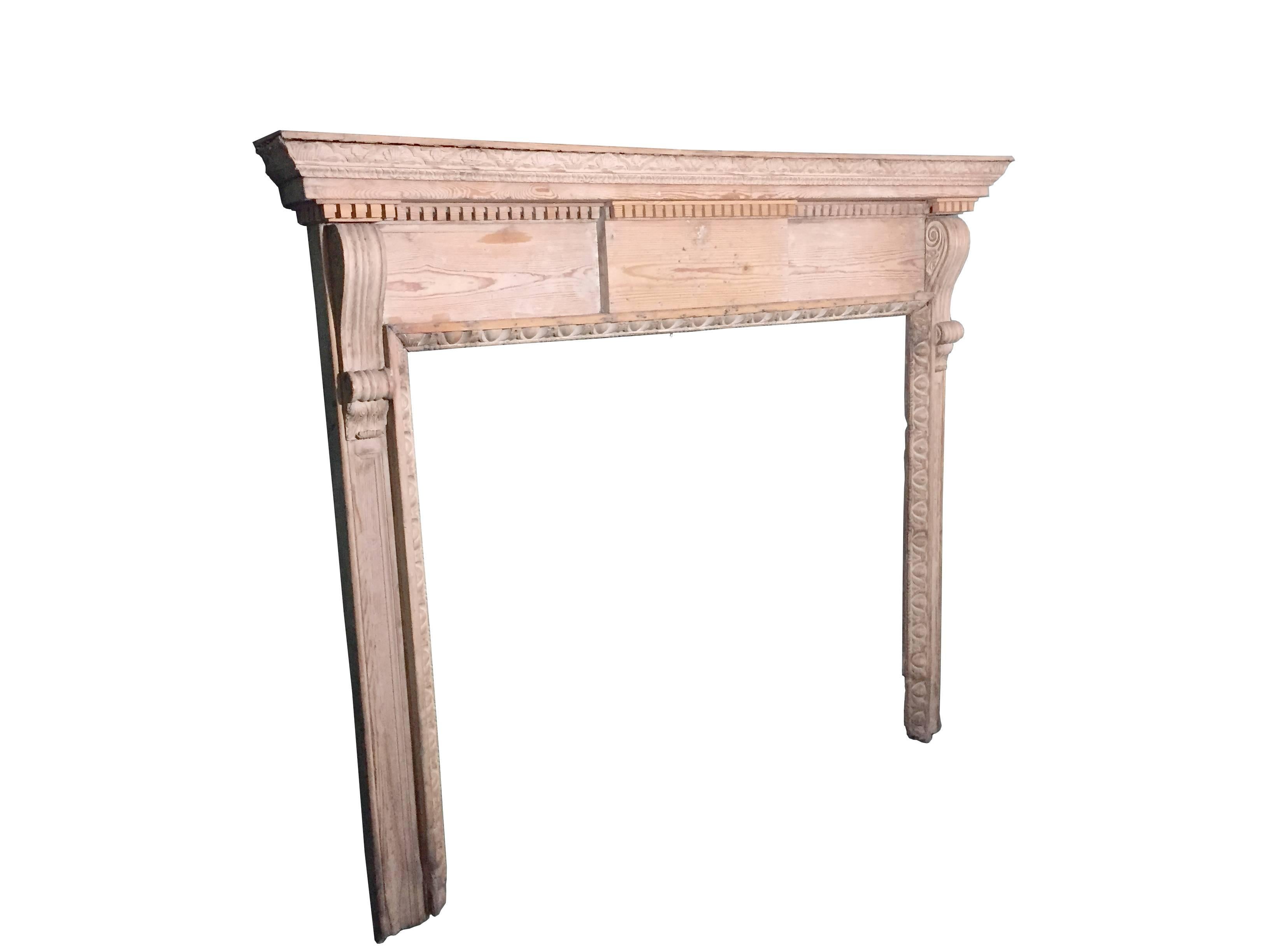 Antique period George II pinewood carved mantle with beautifully carved cornice above a dentilled carved molding. Flanked at each side with classical scrolls, finely carved. The opening has an egg and dart molding all finely carved. This