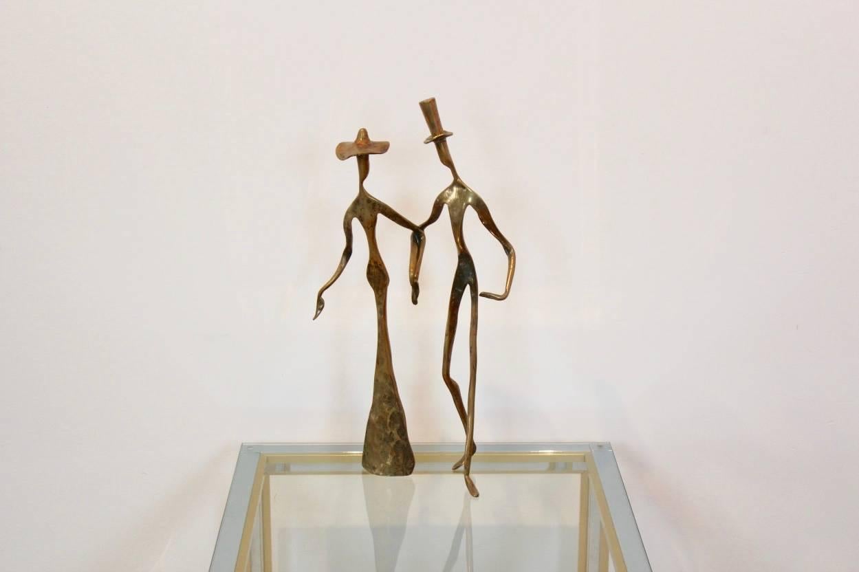 A truly eye-catching, unusual bronze sculpture of a couple holding hands tenderly. Very elegant and beautifully styled with nice patina. Produced circa 1970s. One of a kind and in excellent condition.
    